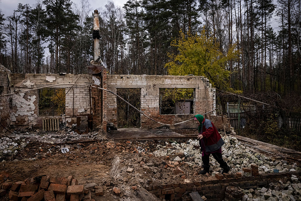 A woman looks at her home, destroyed during battles at the start of Russia's full scale invasion, in Yahidne village on October 30, in Chernihiv, Ukraine. 