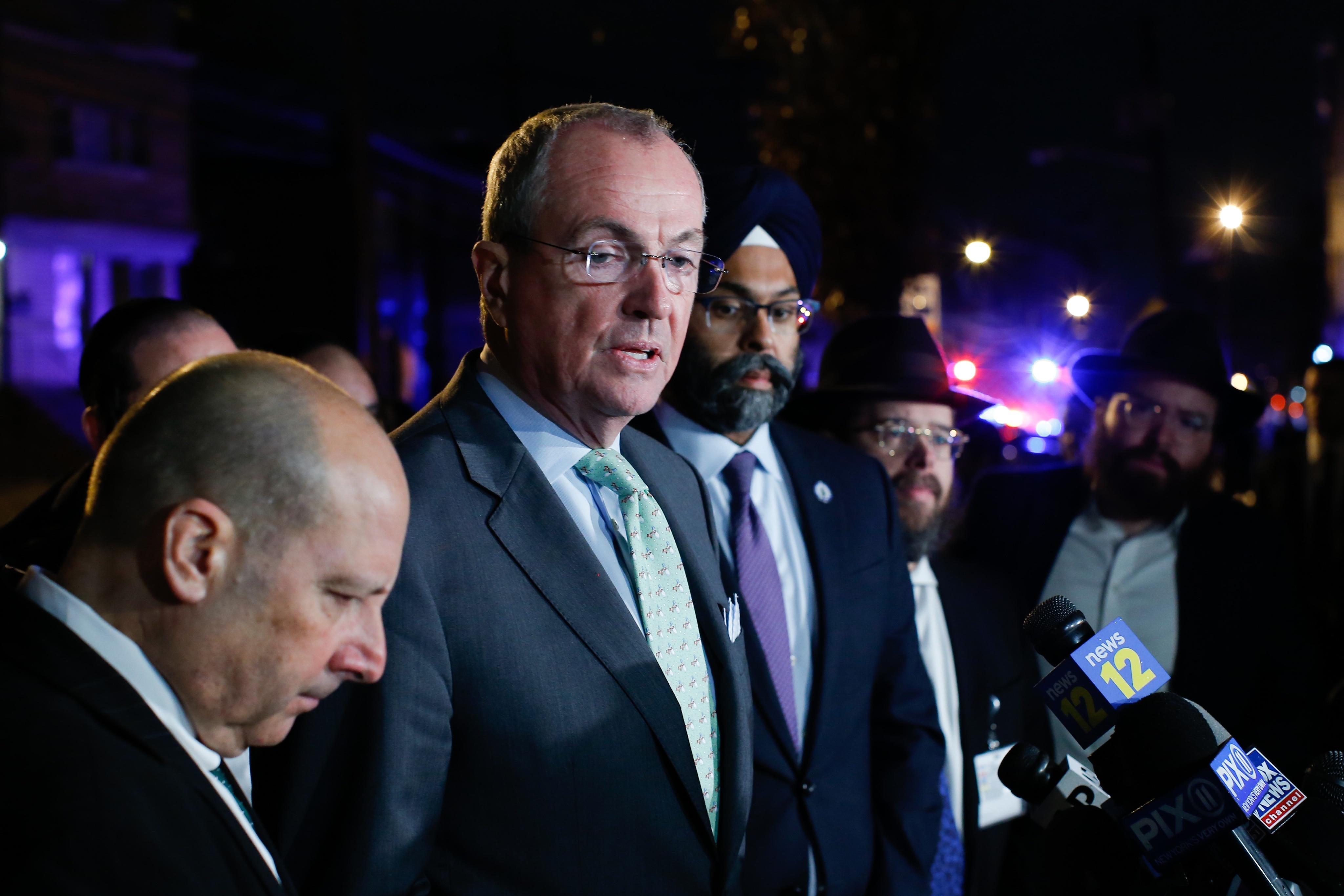 New Jersey Gov. Phil Murphy speaks with reporters near the scene a shooting in Jersey City. 