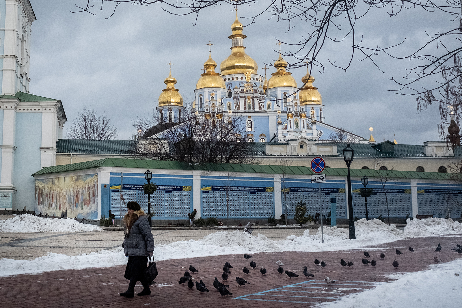 Seorang wanita berjalan melewati Wall of Remembrance di depan Biara St. Michael pada 1 Februari 2022 di Kyiv, Ukraina. 