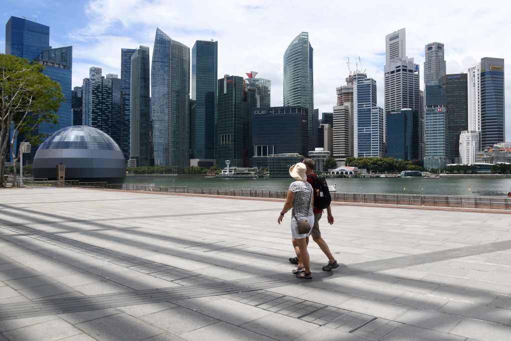 Visitors walk along a walkway at Marina Bay in Singapore on February 18, 2020.