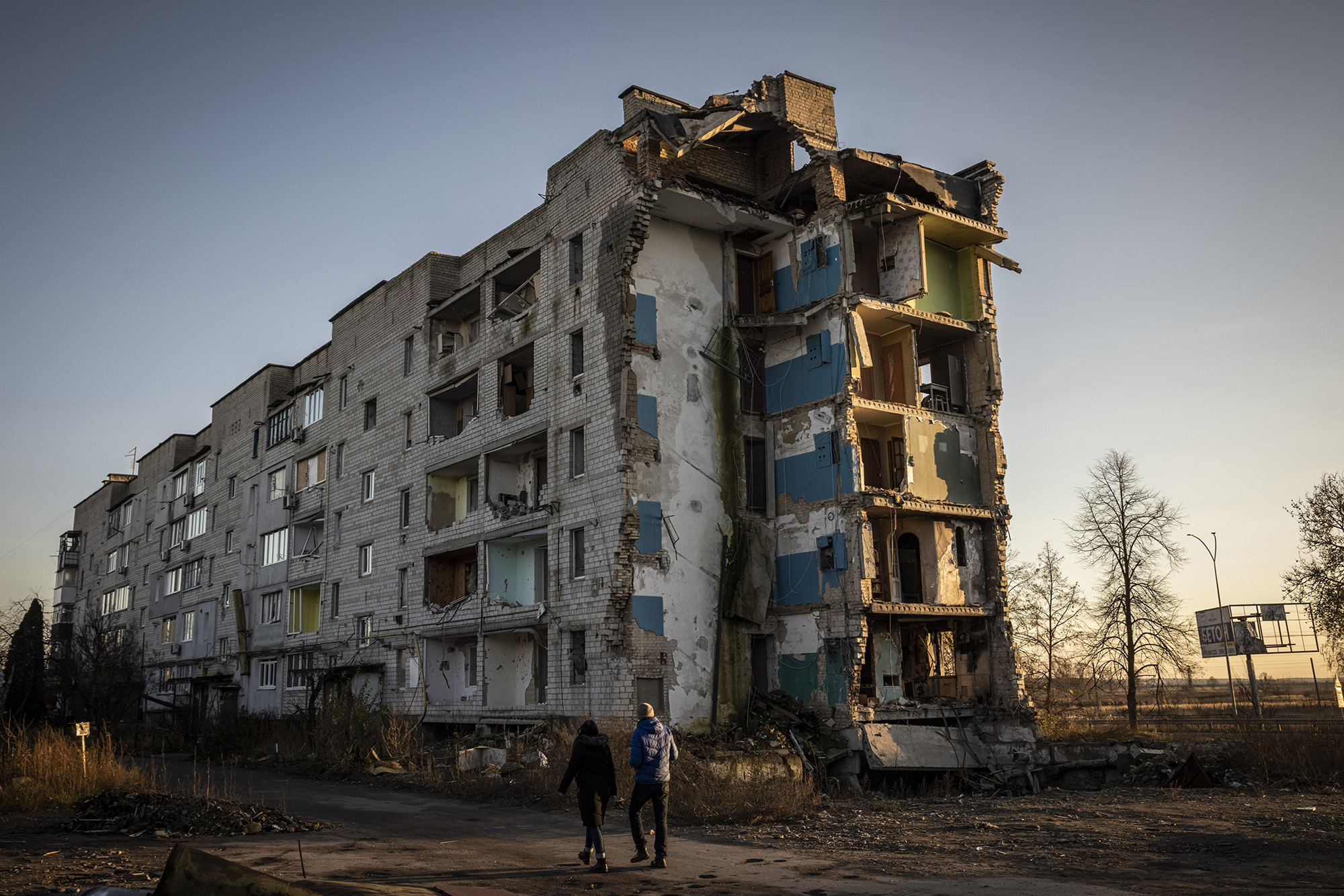 People walk past damaged buildings in Borodyanka, Ukraine, on November 9.