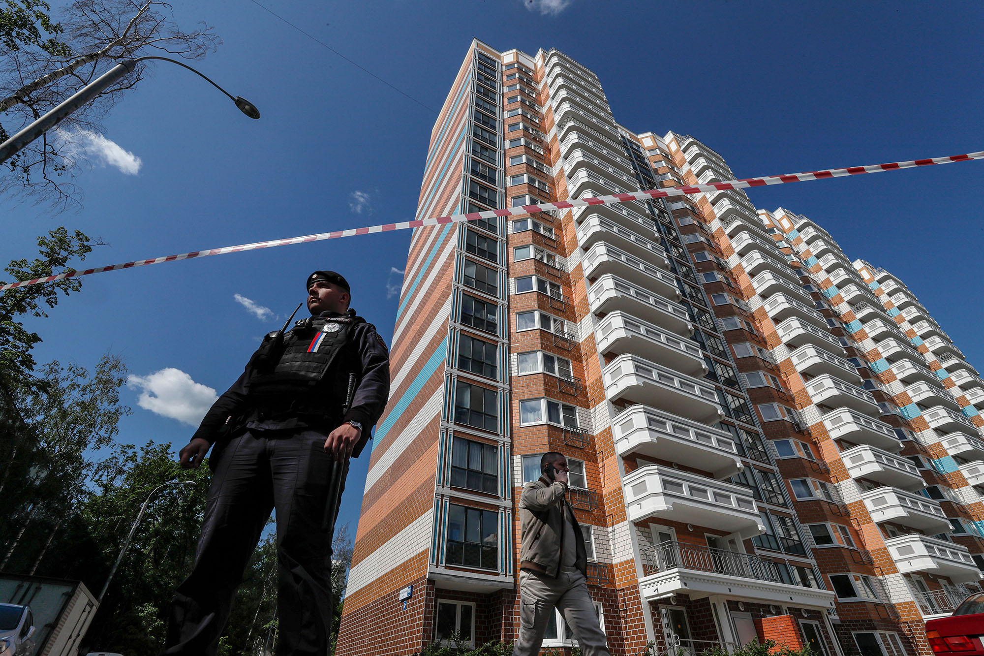 A Russian policeman stands guard near a damaged residential building following a reported drone attack in Moscow, Russia, on May 30. 