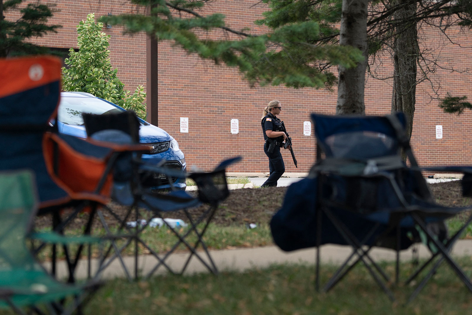 An armed law enforcement officer patrols the scene of the Fourth of July parade shooting in Highland Park, Illinois, on July 4.