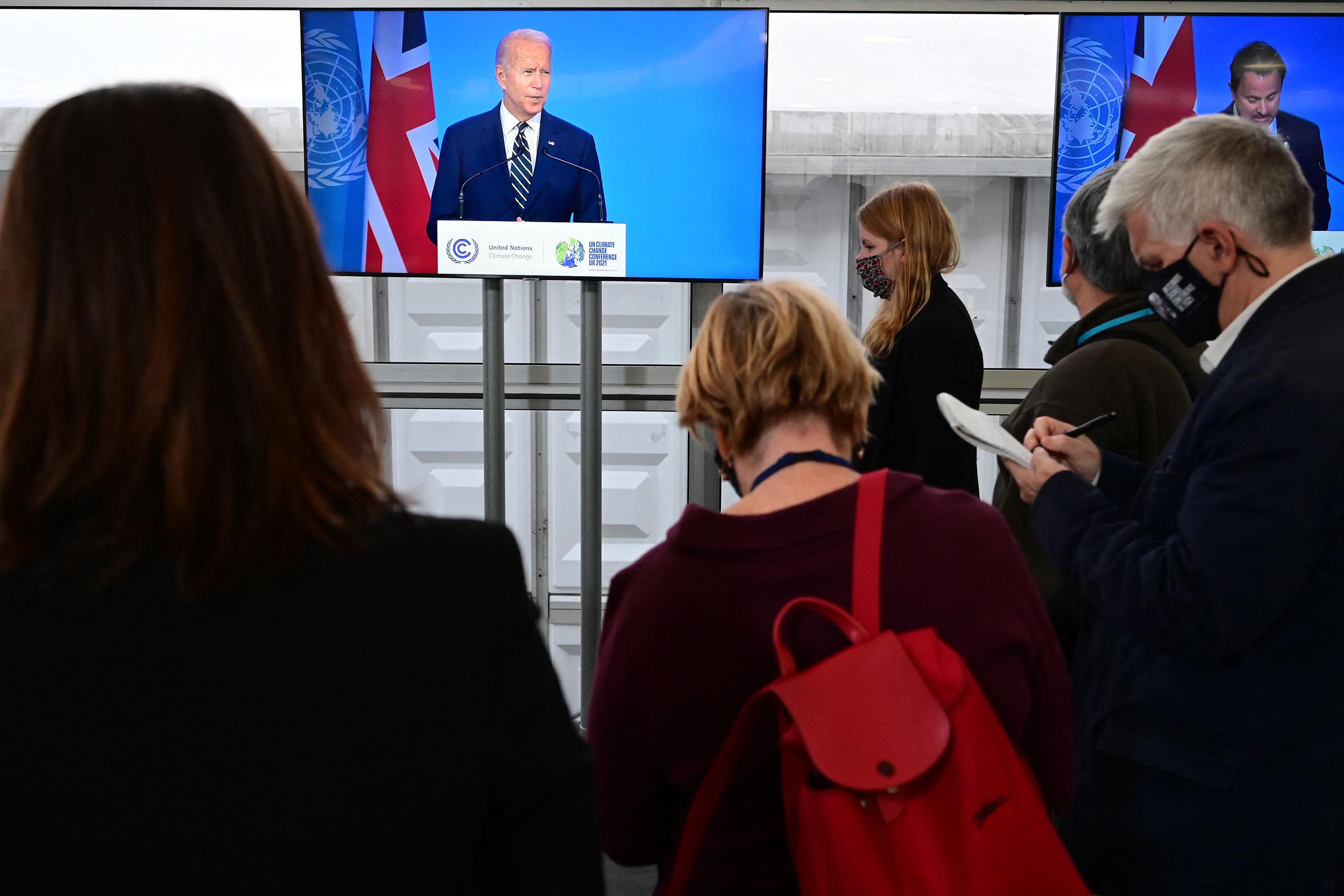 Journalists take notes as they listen to US President Joe Biden present his national statement as part of the World Leaders' Summit of the COP26 UN Climate Change Conference in Glasgow, Scotland on November 1.