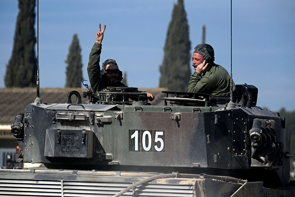 A Ukrainian soldier signs a 'V' for victory as he receives training on Leopard 2 battle tanks at the Spanish army's training center of San Gregorio in Zaragoza on March 13.