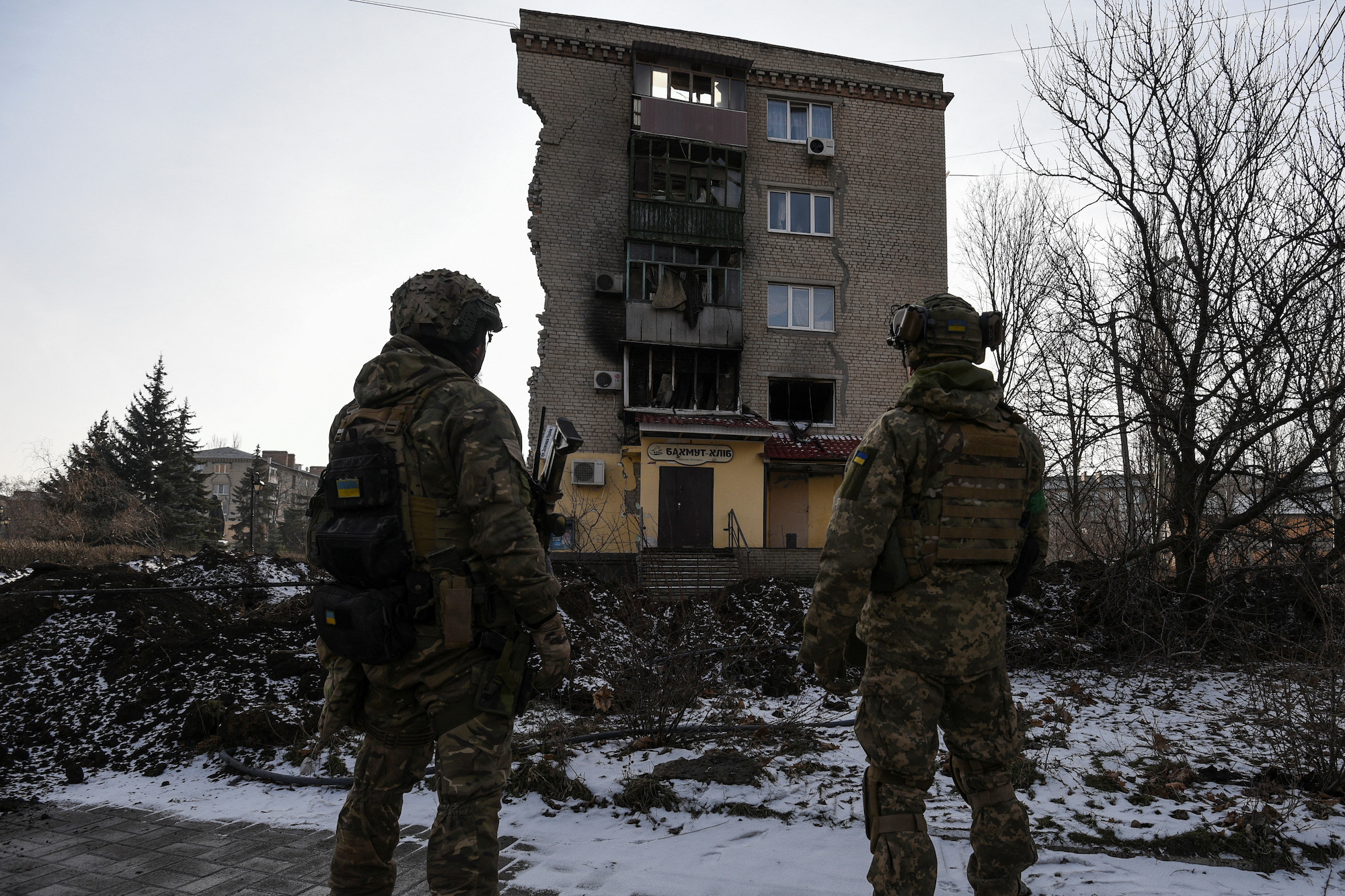 Ukrainian servicemen stand near a residential building heavily damaged during a Russian military strike in Bakhmut on Tuesday.