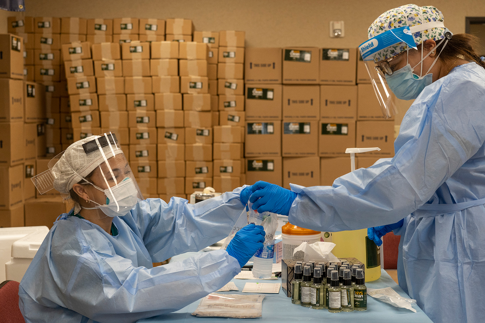 Medical workers from New York wearing personal protective equipments handle test samples at temporary testing site for Covid-19 in Higher Dimensions Church on July 17, in Houston.