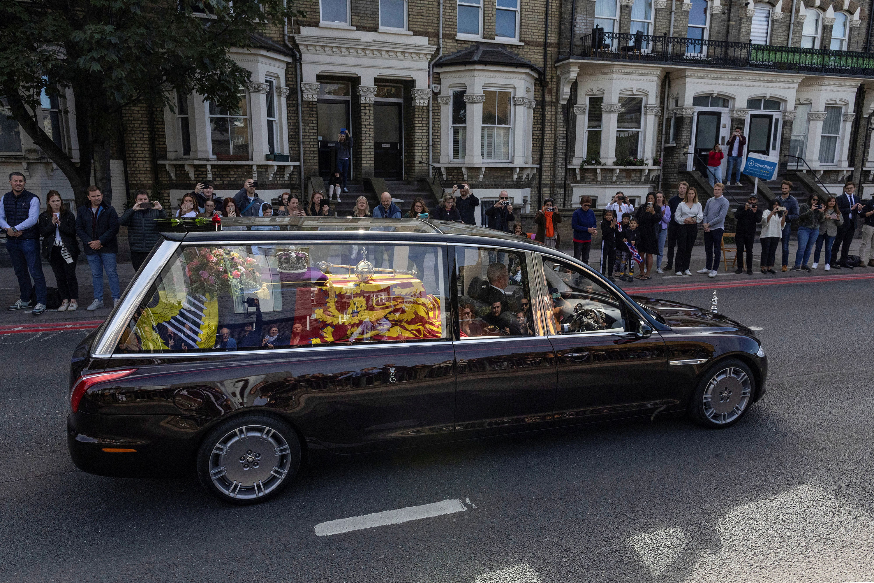 People watch as the Queen's coffin is transported from London to Windsor.