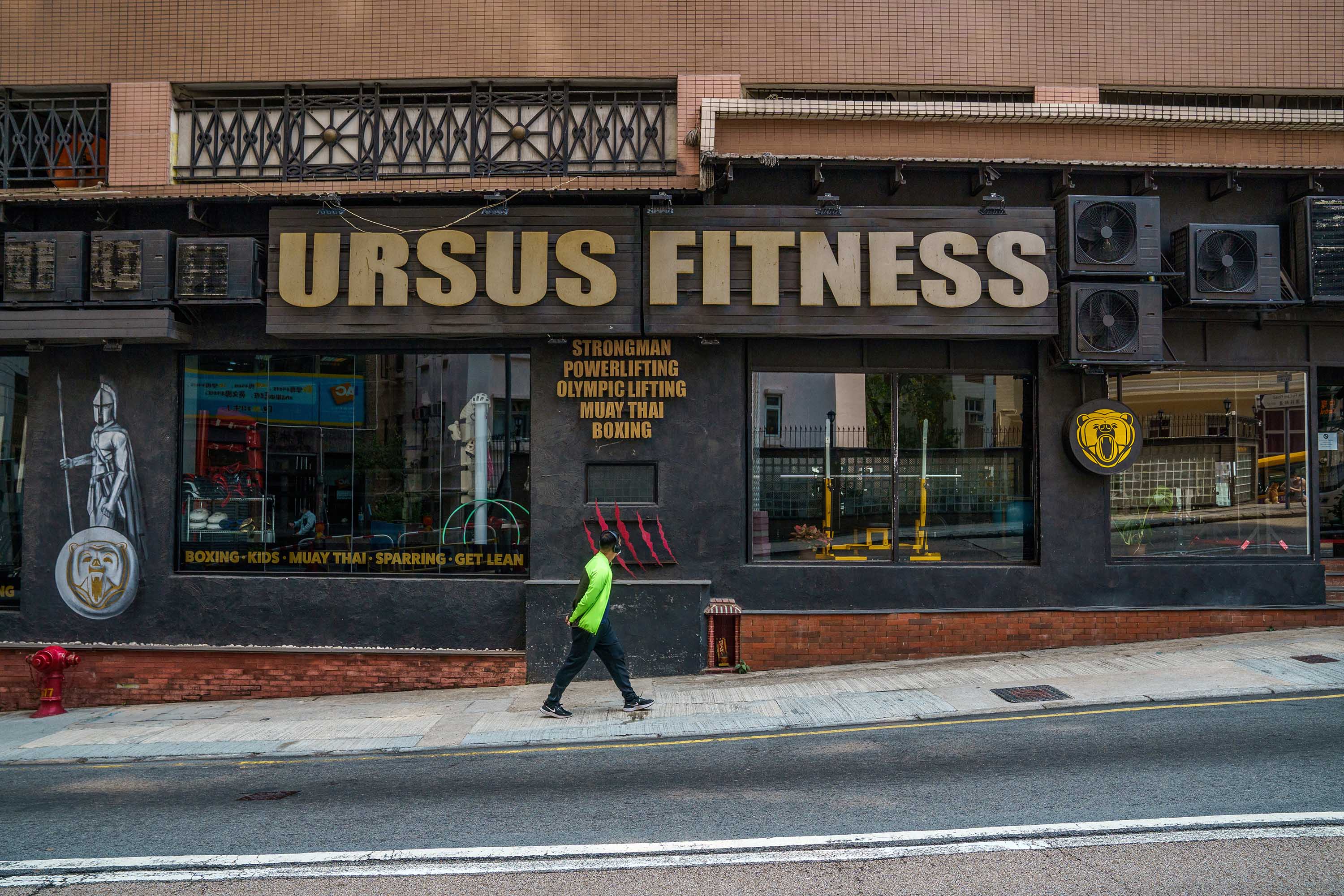 A pedestrian walks past the closed Ursus Fitness center in Hong Kong, China, on Friday, March 12. 