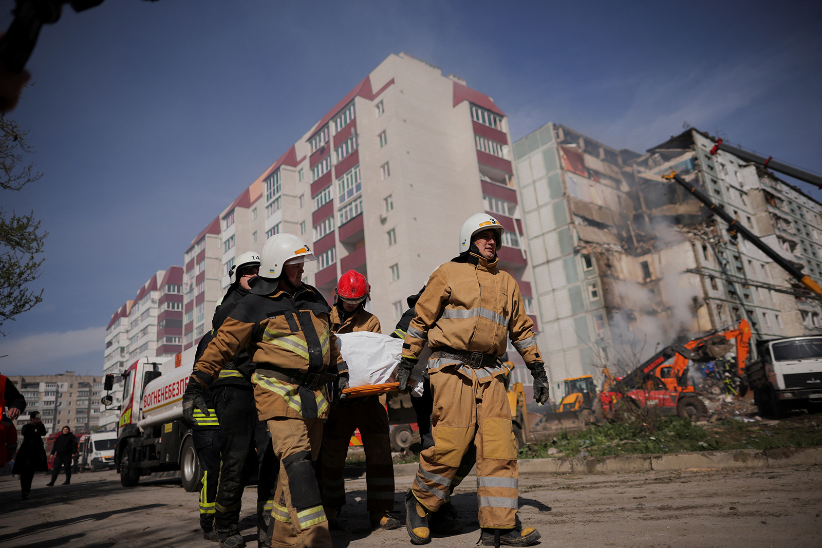 Rescuers carry the body of a victim as they work at the site of a heavily damaged residential building hit by a Russian missilein in Uman, Cherkasy region, Ukraine on April 28.