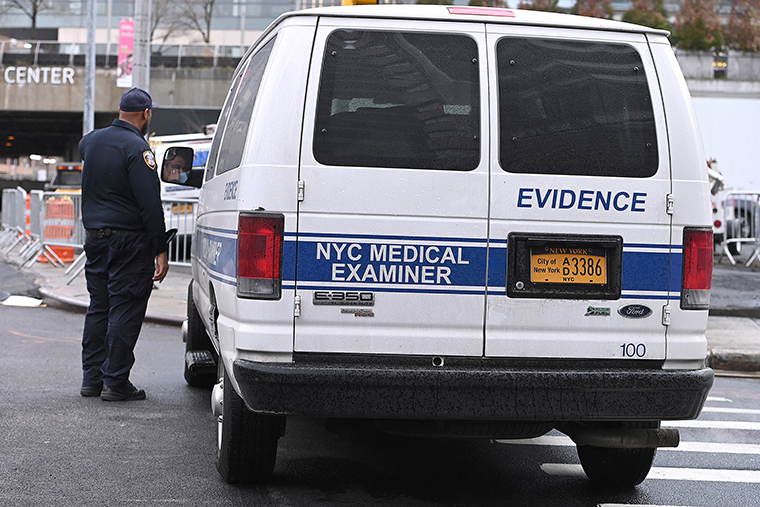 An NYC Medical Examiner's van is parked along the street where members Air Force Reserve set up tents and medical related equipment as they build a makeshift morgue outside Bellevue Hospital to handle potential high number of Coronavirus victims, on Wednesday, March 25, in New York City.