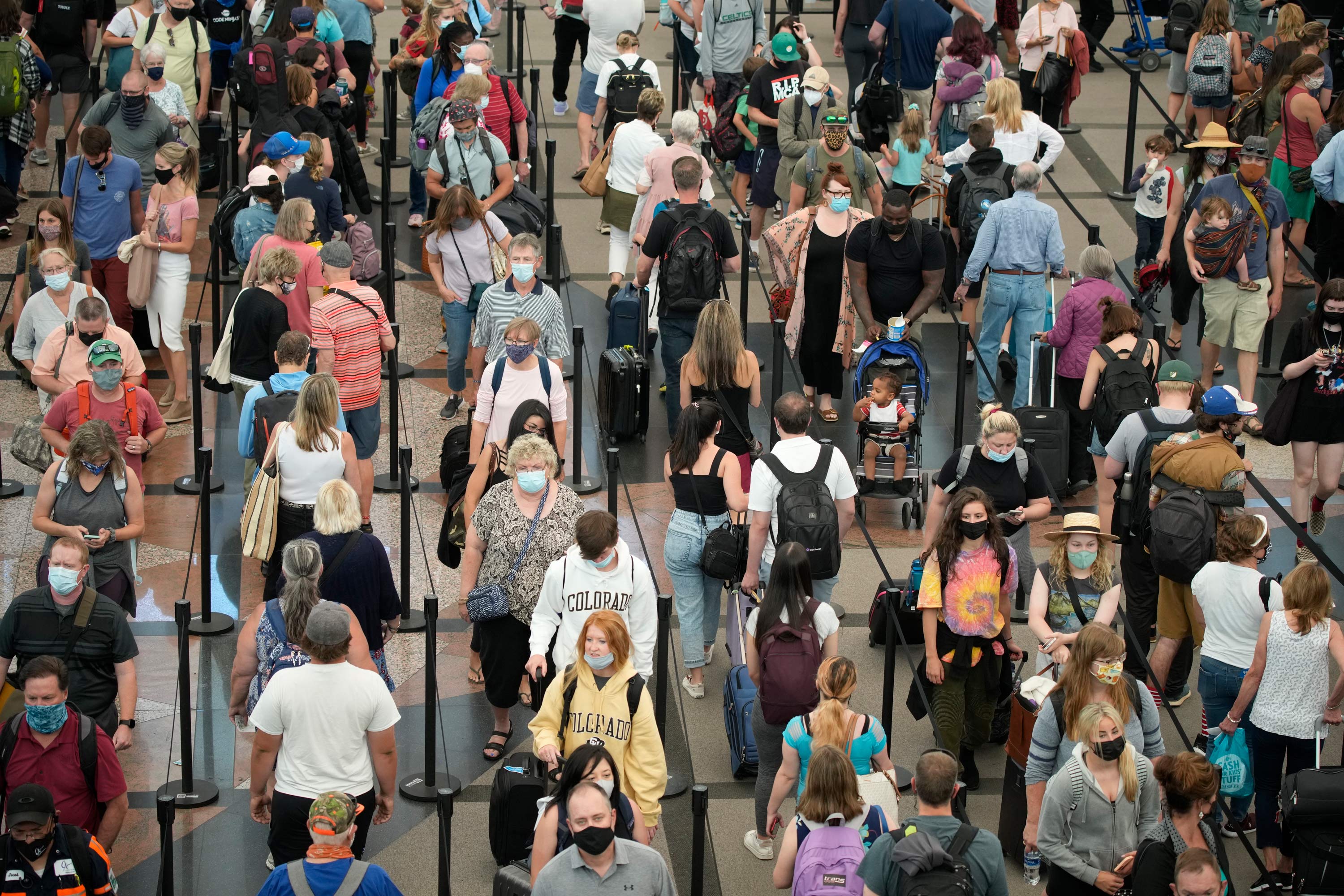 Travelers line up to pass through the south security checkpoint at Denver International Airport on June 16 in Denver. 