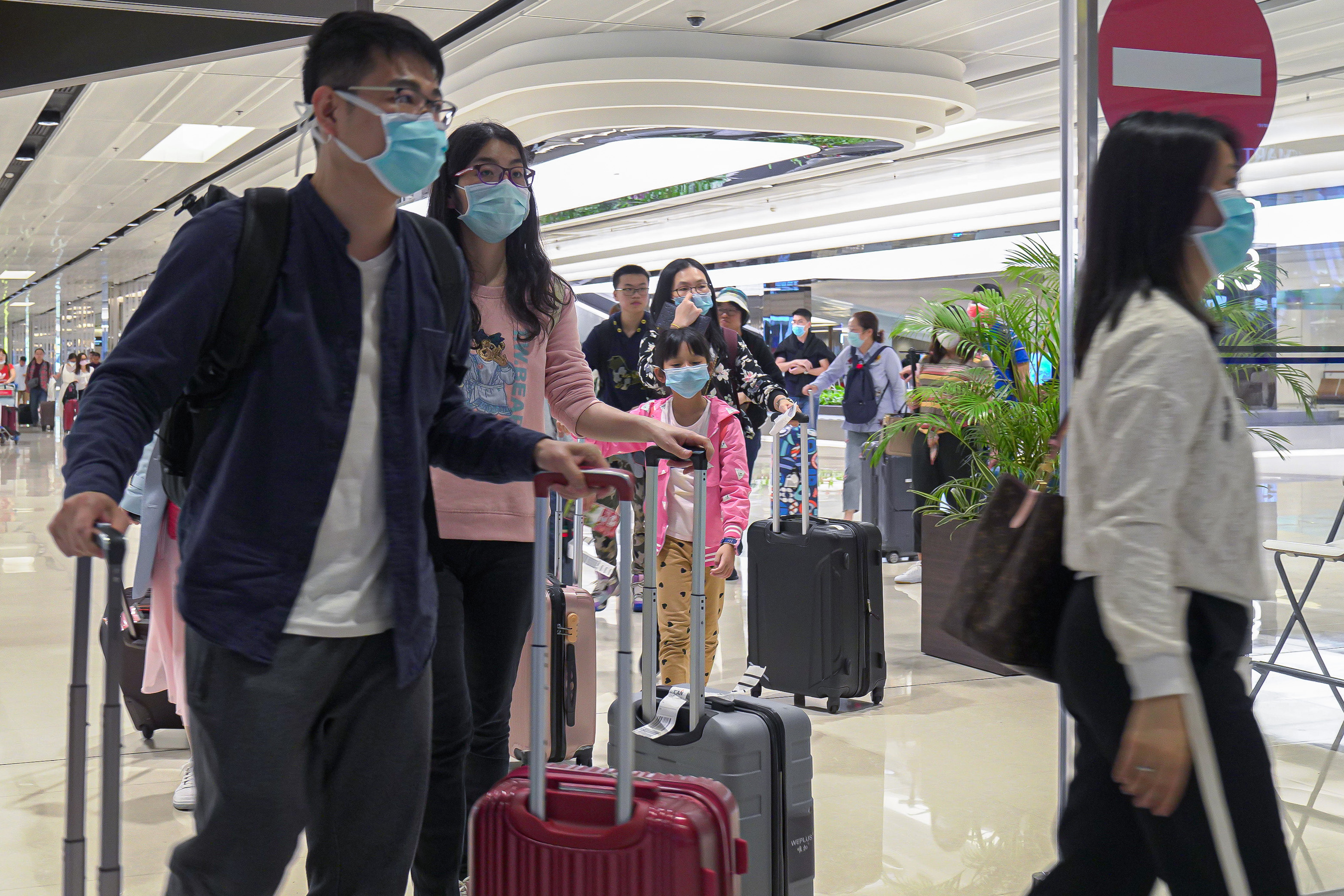  Visitors wearing masks arrive at the departure hall of Changi Airport in Singapore.