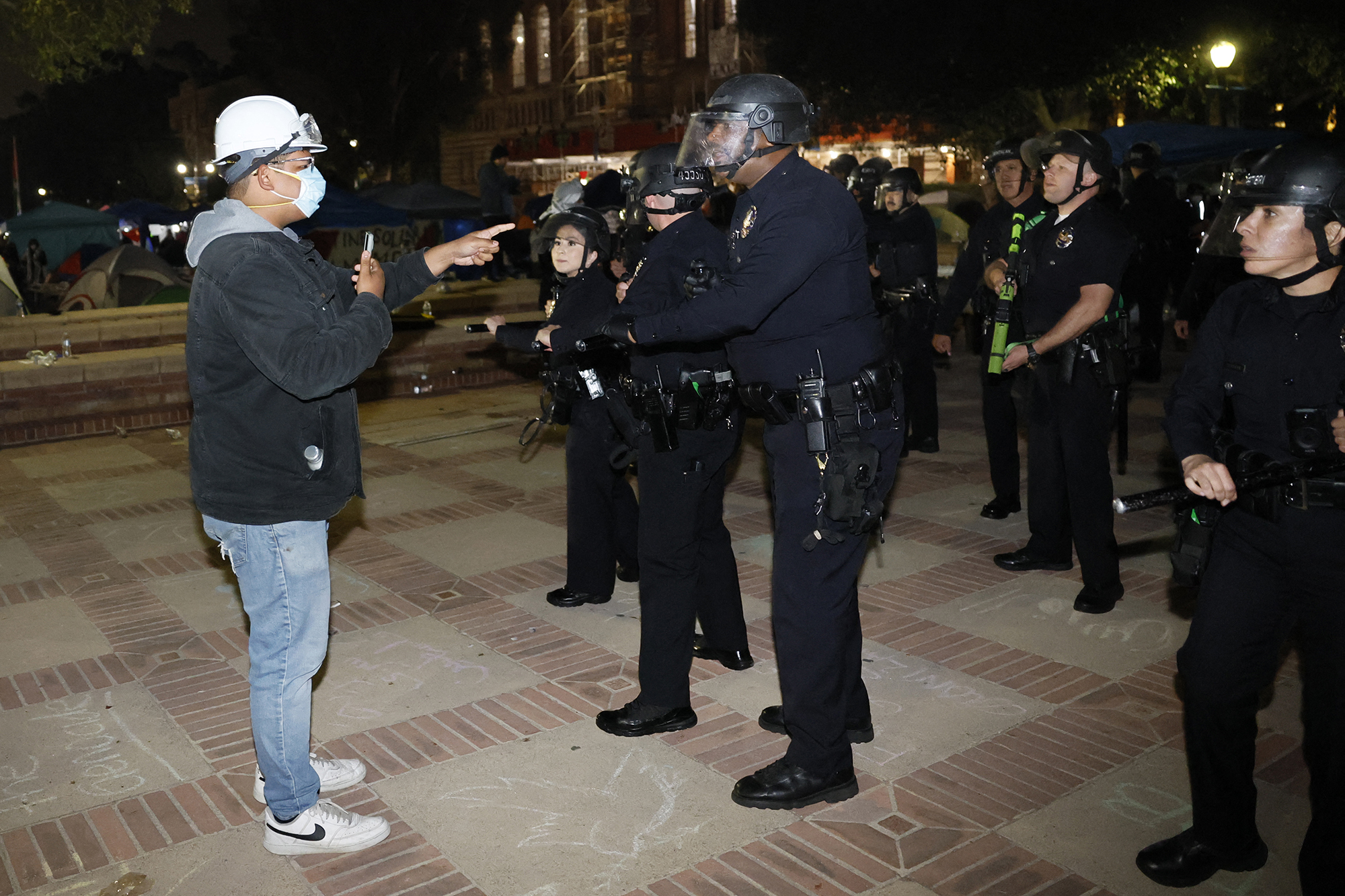 An activist confronts police as they breach the encampment of Pro-Palestinian students demonstrating on the campus of UCLA in Los Angeles, California, early on May 2.
