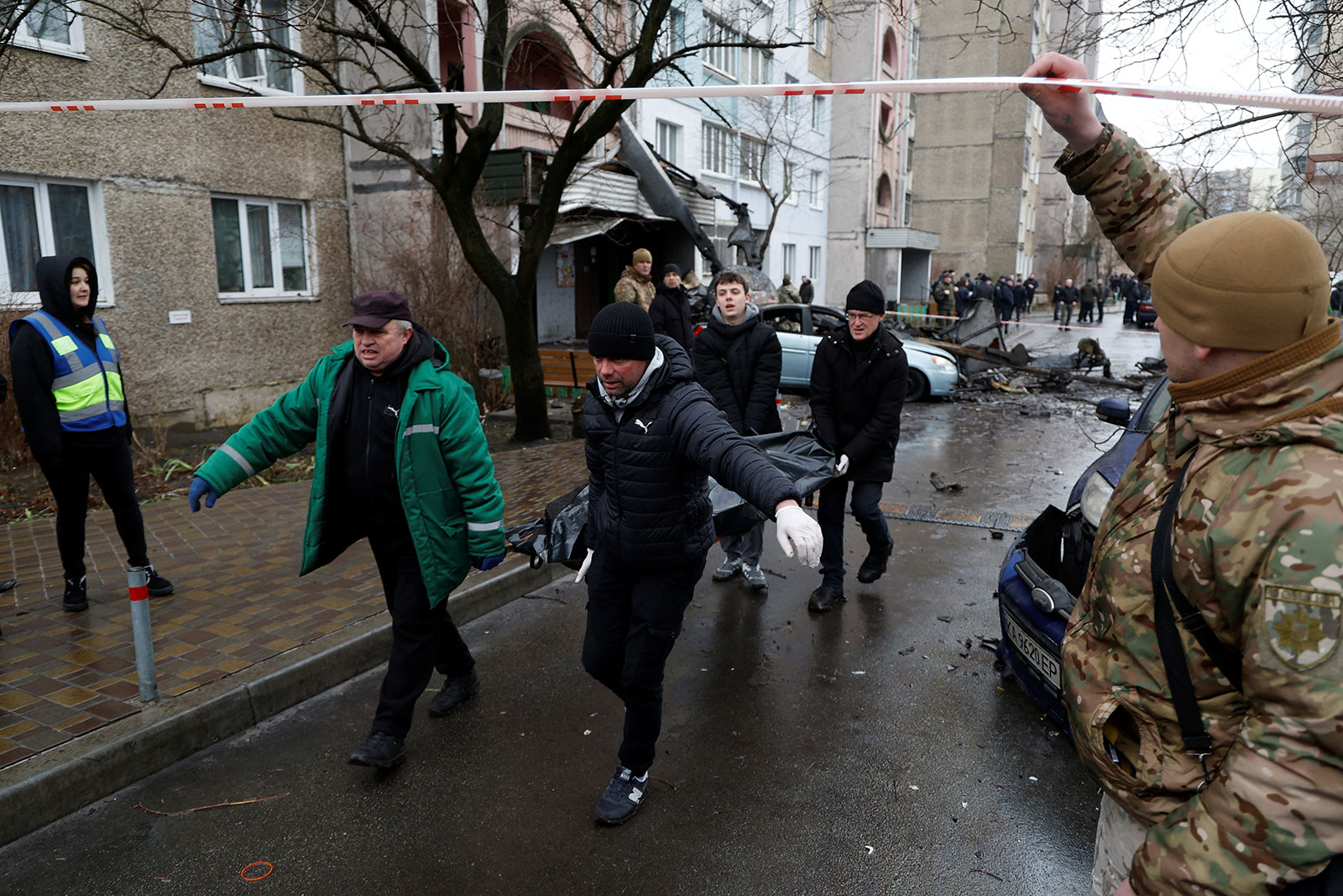 People carry away a body from the site of the helicopter crash in Brovary on Wednesday. 