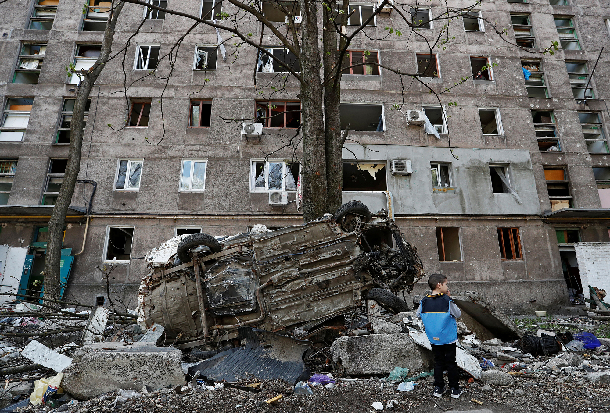 A boy stands near damage and debris in Mariupol, Ukraine on April 24. 