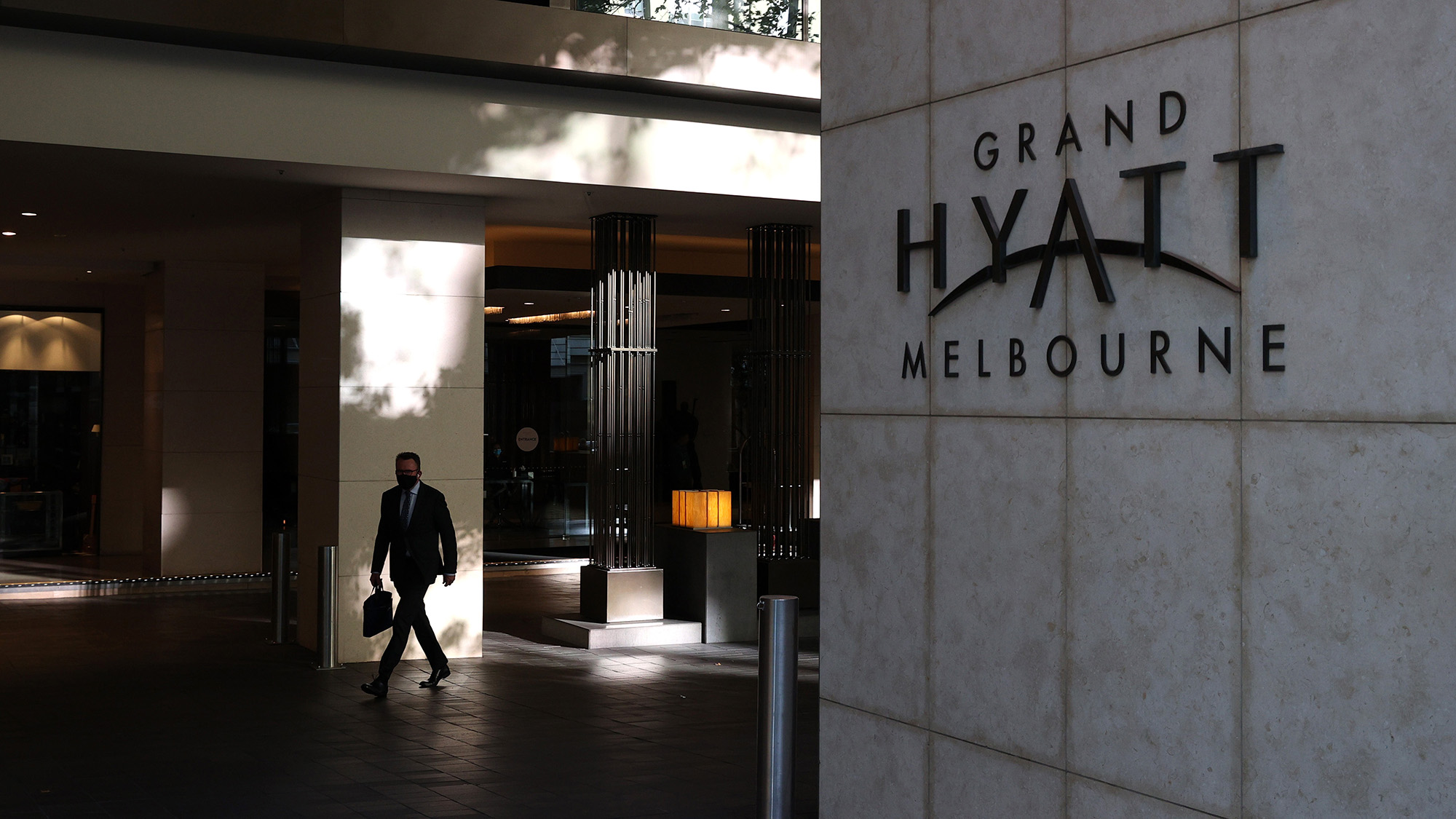 A man wearing a protective face mask is seen outside the Grand Hyatt in Melbourne.
