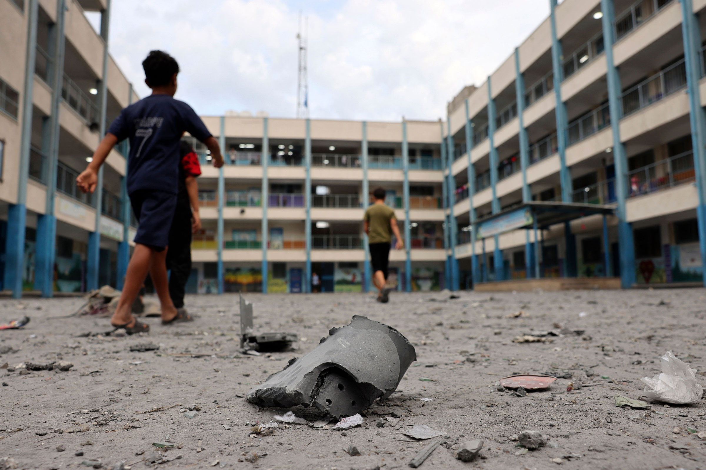 Palestian children walks past debris in the courtyard of a school run by the United Nations Relief and Works Agency for Palestine refugees following Israeli airstrikes targeting Gaza City on October 9. 