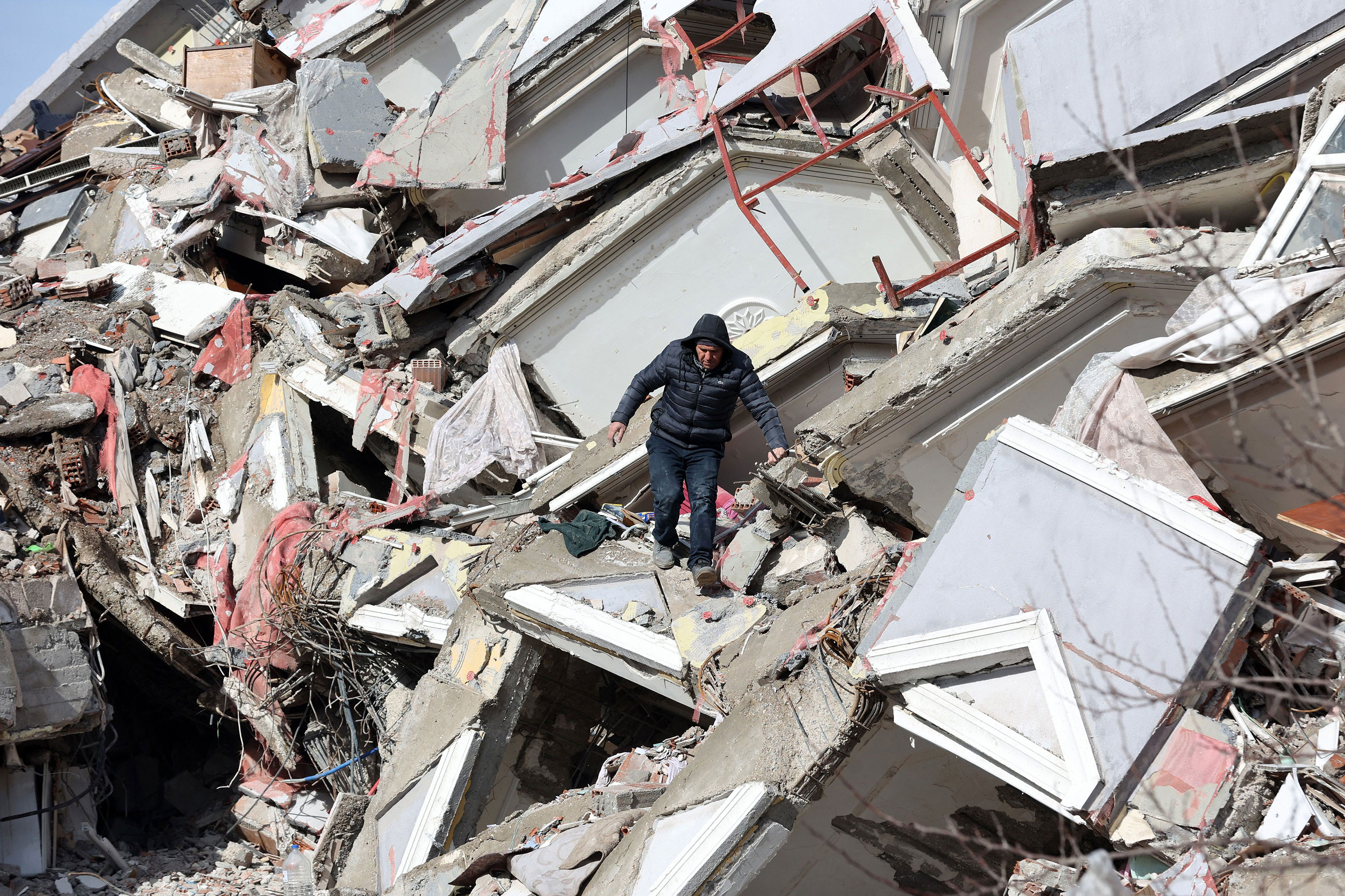 A man walks down the rubble of a collapsed building in Kahramanmaras, Turkey, on Tuesday.
