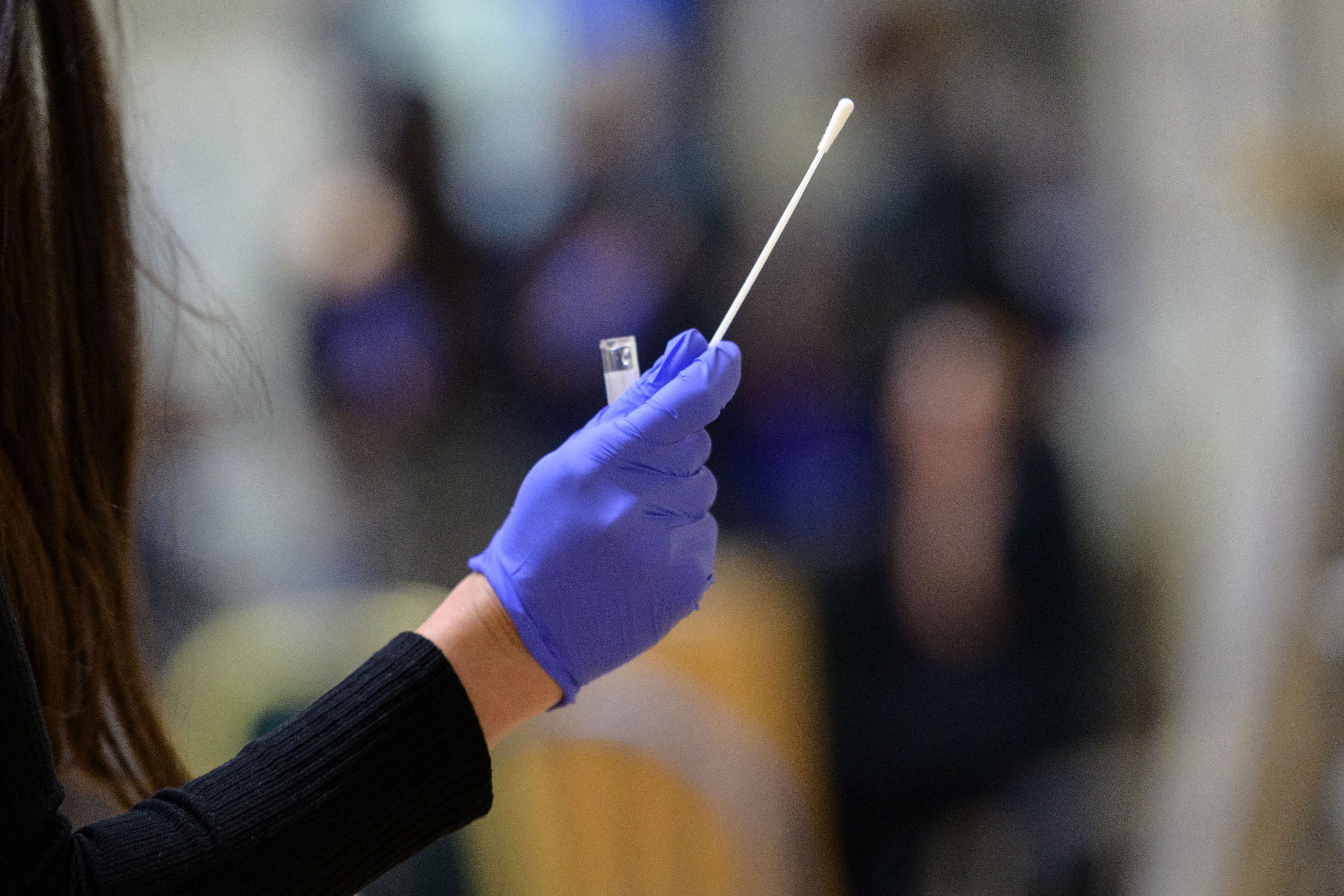 A nurse holds a nasal swab to test for coronavirus on April 27 in New York.