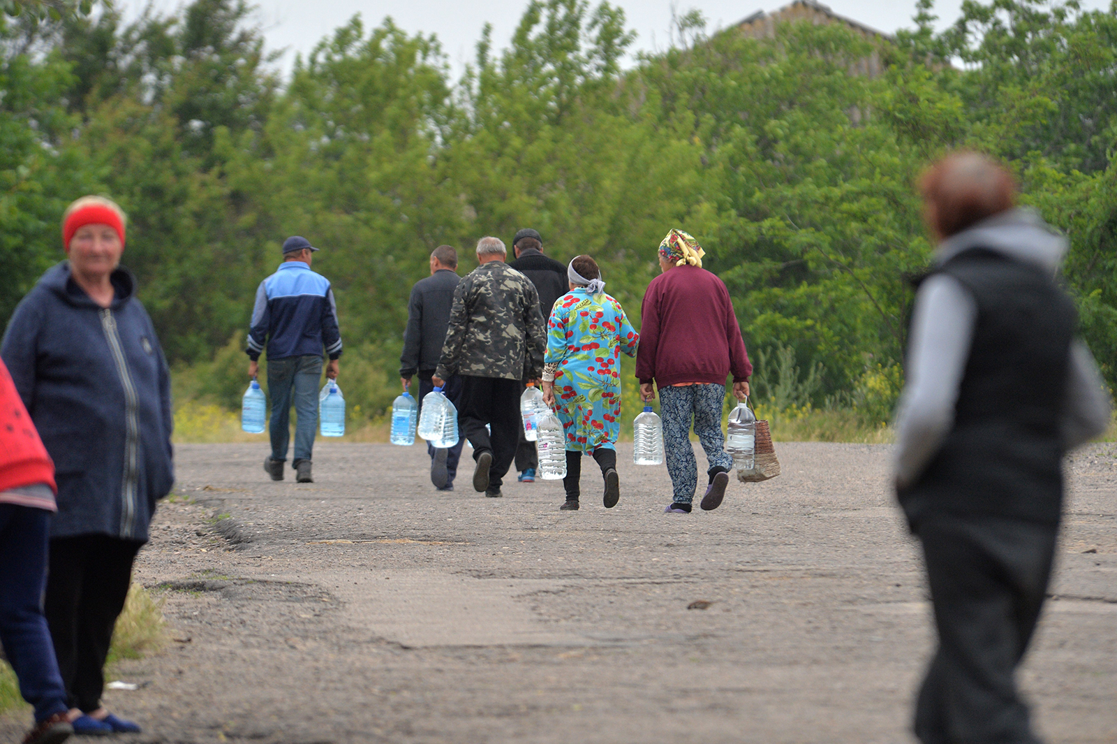 Residents carry bottled water in Mykolaiv region, Ukraine, on June 12. 