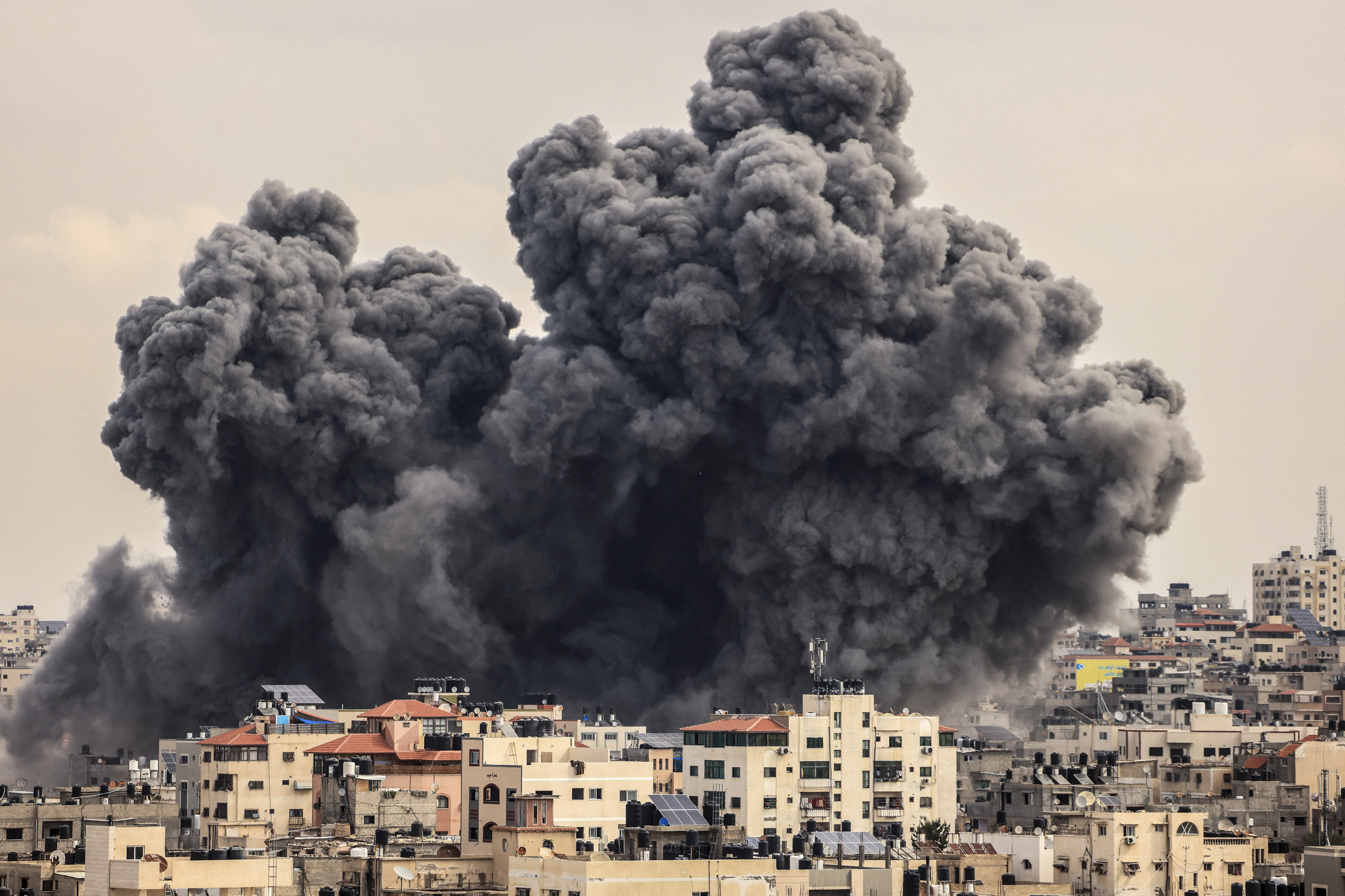 A plume of smoke rises in the sky over Gaza City during an Israeli airstrike on October 9, 2023.