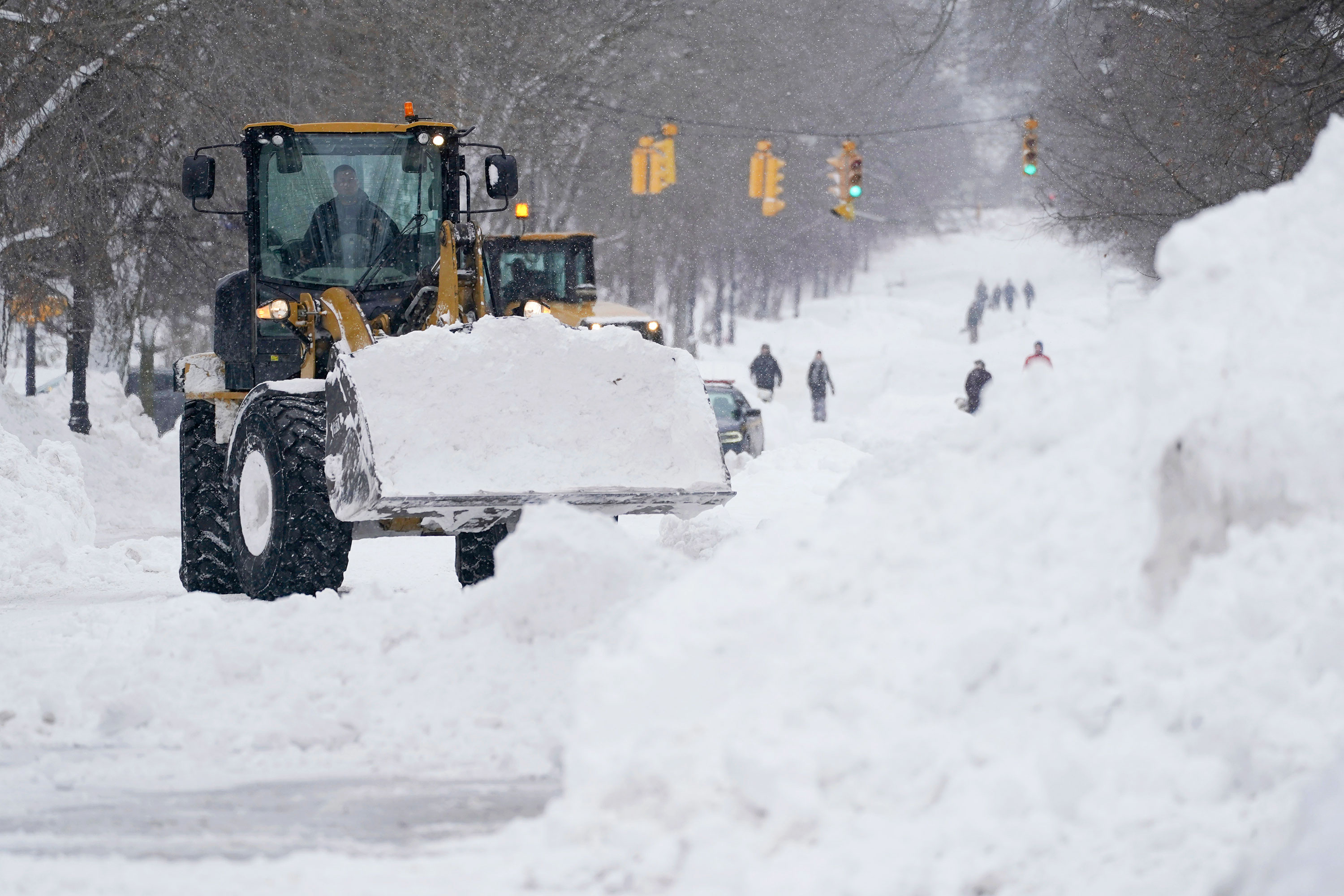 Workers use heavy equipment to clear snow from Richmond Avenue in Buffalo on Monday.