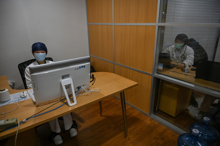 Doctors take video calls from patients suffering various symptoms and illnesses, to avoid crowding at Xuhui District Hospital in Shanghai on March 9.