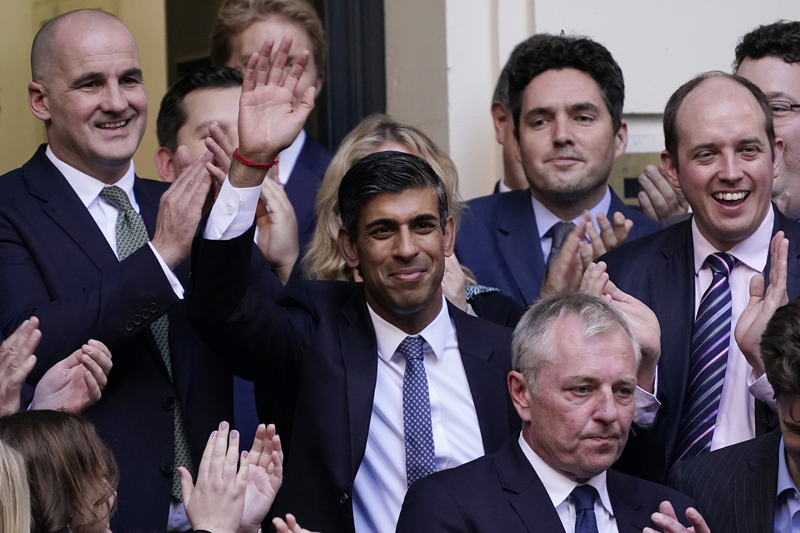 Rishi Sunak, center, waves after winning the Conservative Party leadership contest at the Conservative party Headquarters in London today.