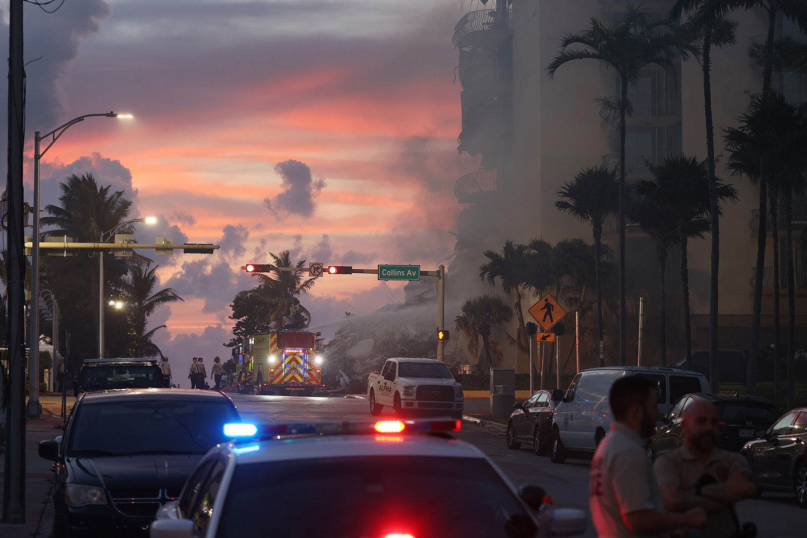 Miami-Dade Fire Rescue personnel spray water on a fire in the partially collapsed 12-story Champlain Towers South condo building as search and rescue operations continue on Friday in Surfside.