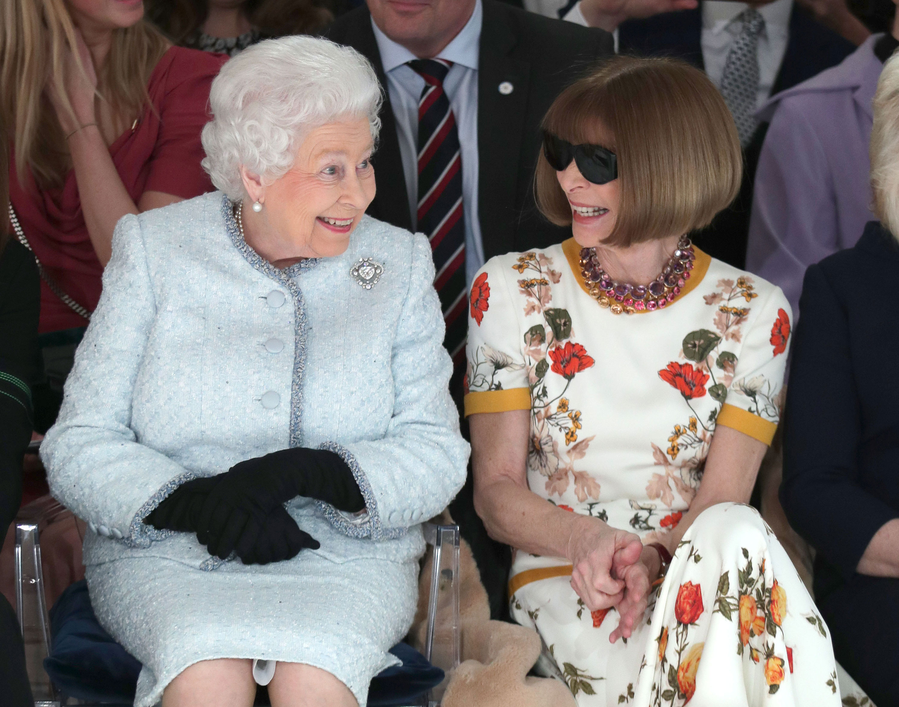Queen Elizabeth sits next to Anna Wintour as they view Richard Quinn's runway show in February 2018 in London.