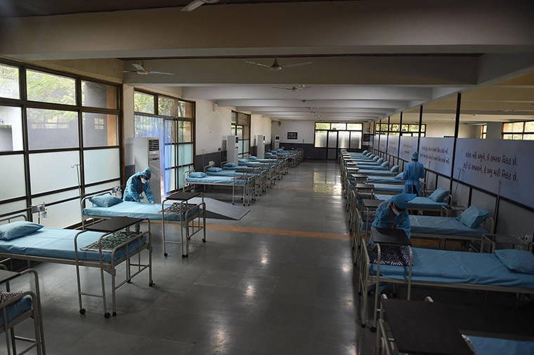 Caretakers arrange beds at the Adani Vidya Mandir school which has been converted into a Covid-19 coronavirus care centre in Makarba, India, on May 5. 