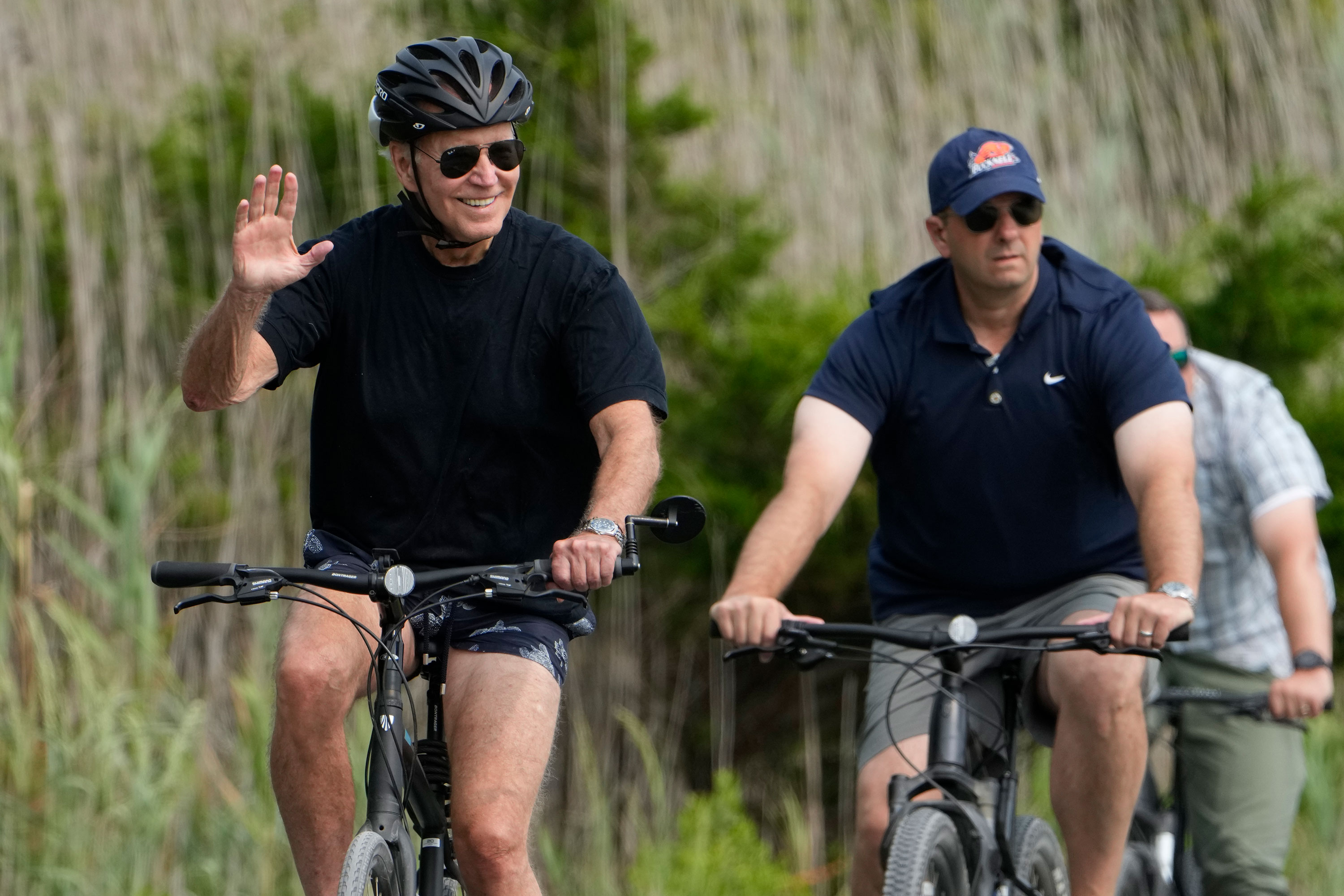 President Joe Biden rides his bike at Gordons Pond in Rehoboth Beach, Delaware, on Thursday.