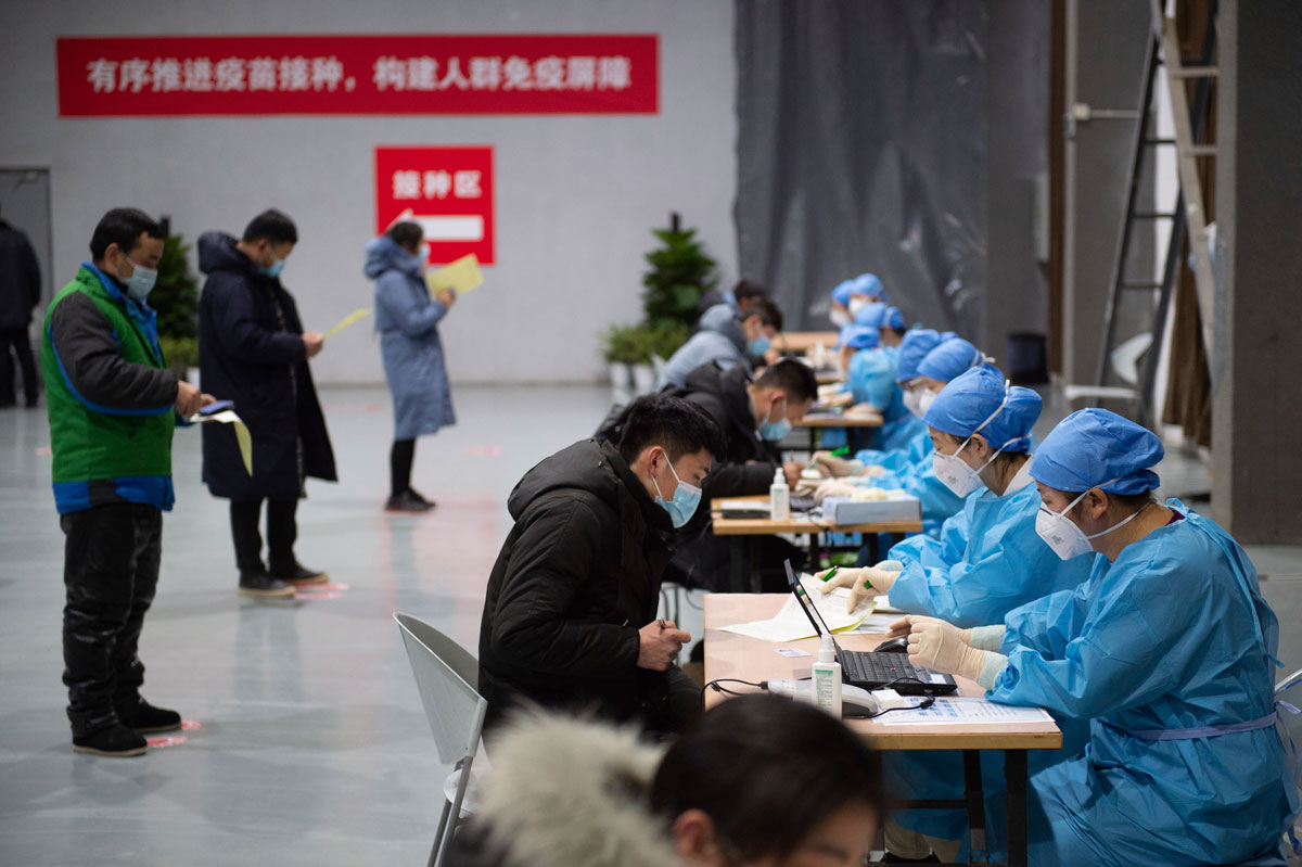 Residents fill out consent forms before receiving their Covid-19 vaccinations at a temporary vaccination site in Beijing, China on January 2.