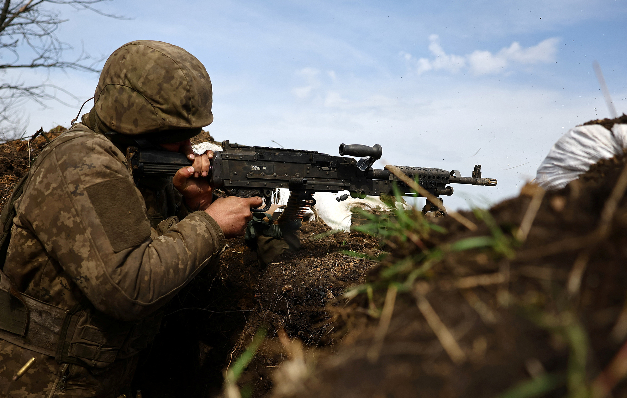 A Ukrainian soldier fires a gun from a trench at the frontline in Bakhmut, Ukraine, on April 5. 
