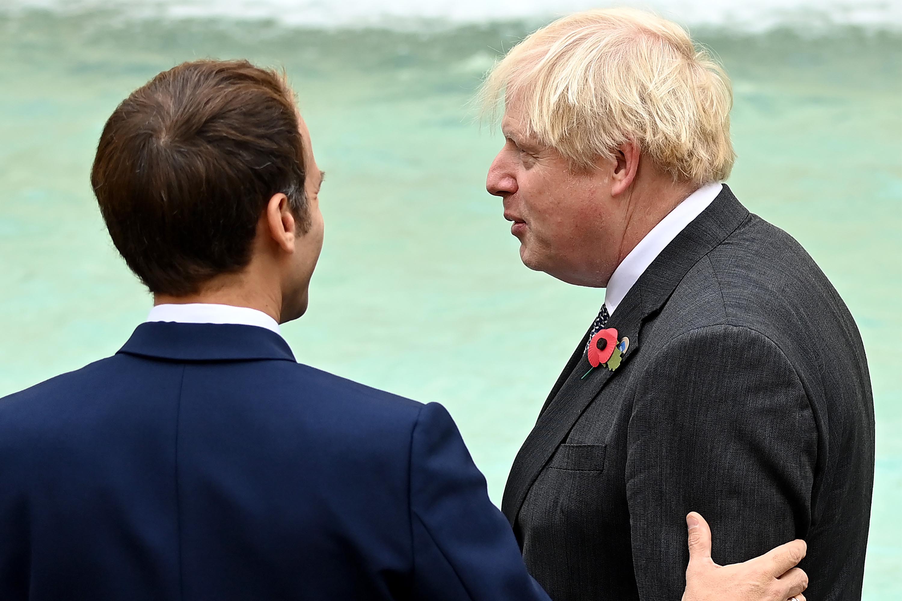 British Prime Minister Boris Johnson speaks to French President Emmanuel Macron during a visit to the Trevi fountain on October 31, 2021 in Rome, Italy.
