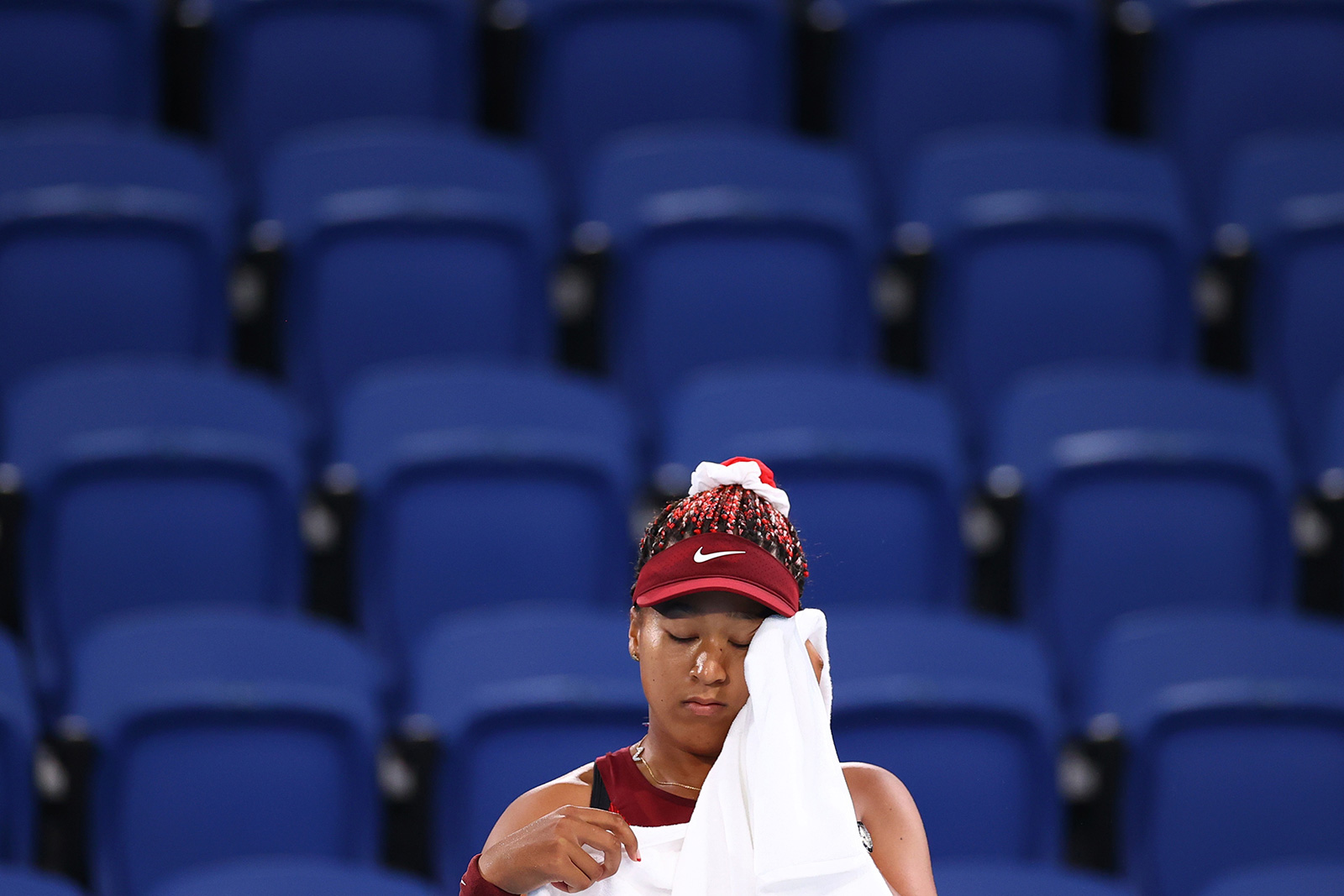 Japan's Naomi Osaka wipes her face after losing her third round match against Marketa Vondrousova of the Czech Republic on Tuesday.