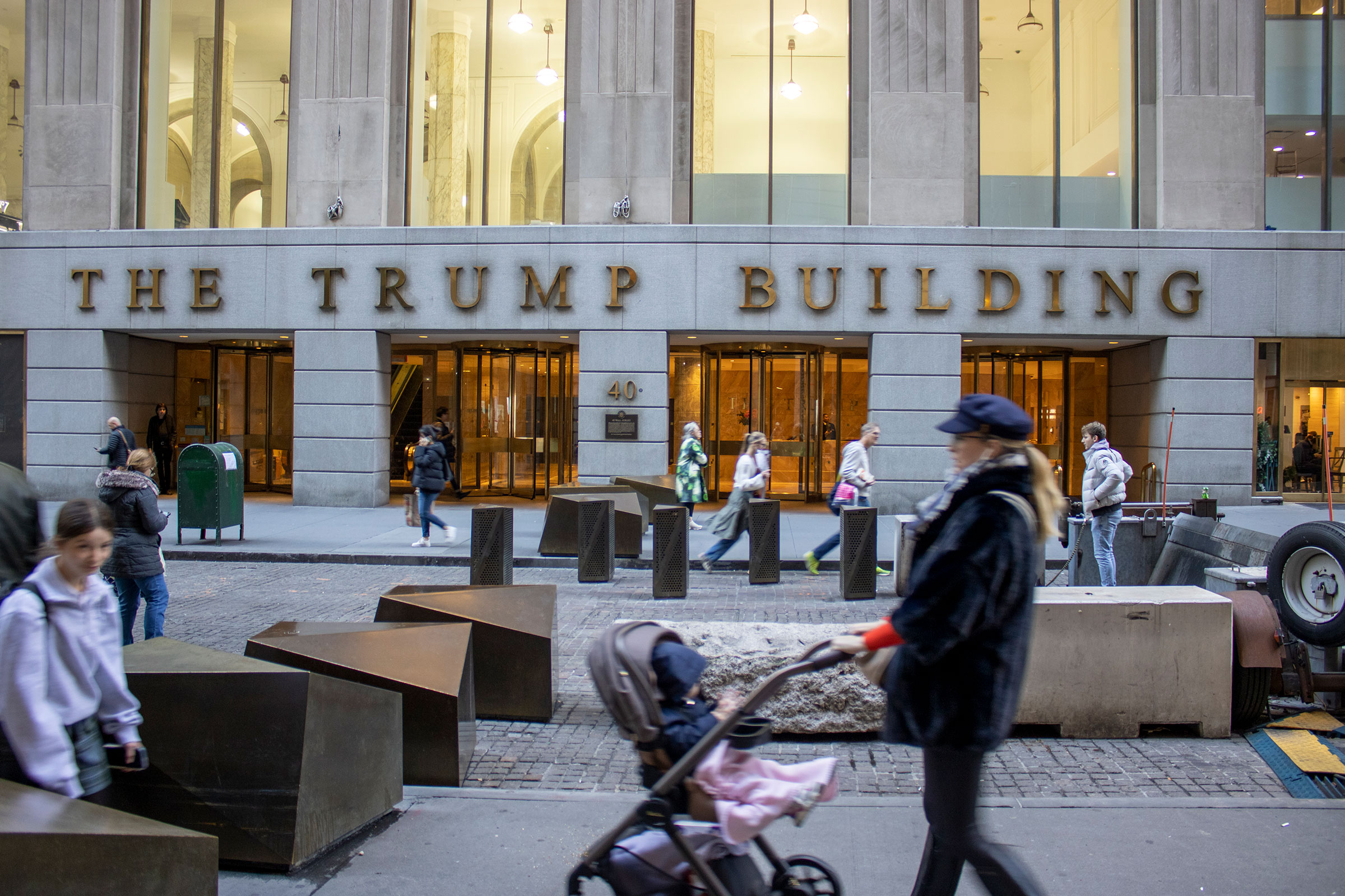 People walk by The Trump Building office building at 40 Wall Street in New York City on Friday, November 3.