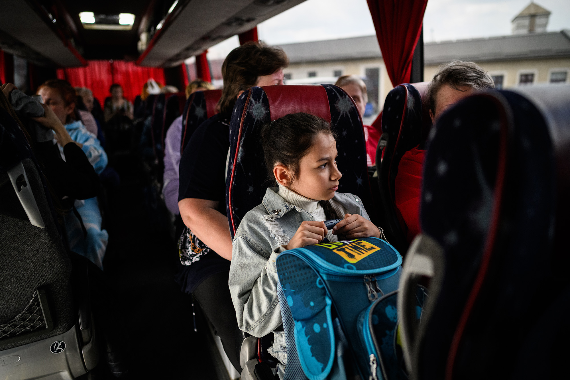 A young girl clutches her backpack as she sits on a bus in Lviv, Ukraine, leaving for Warsaw in Poland, carrying refugees from regions of southern and eastern Ukraine, on May 3.