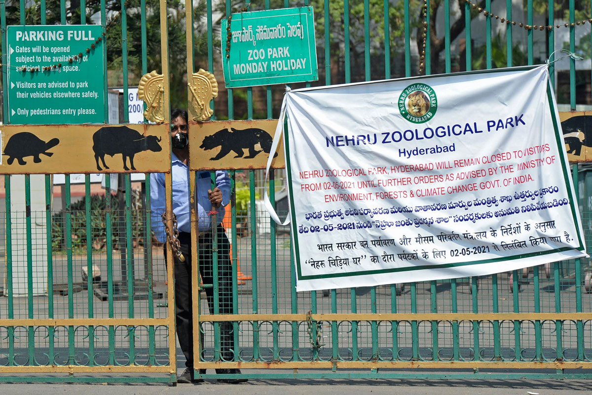 A security guard watches through the entrance gate of the Nehru Zoological Park after it was closed for visitors amid the coronavirus pandemic in Hyderabad, India on May 4.