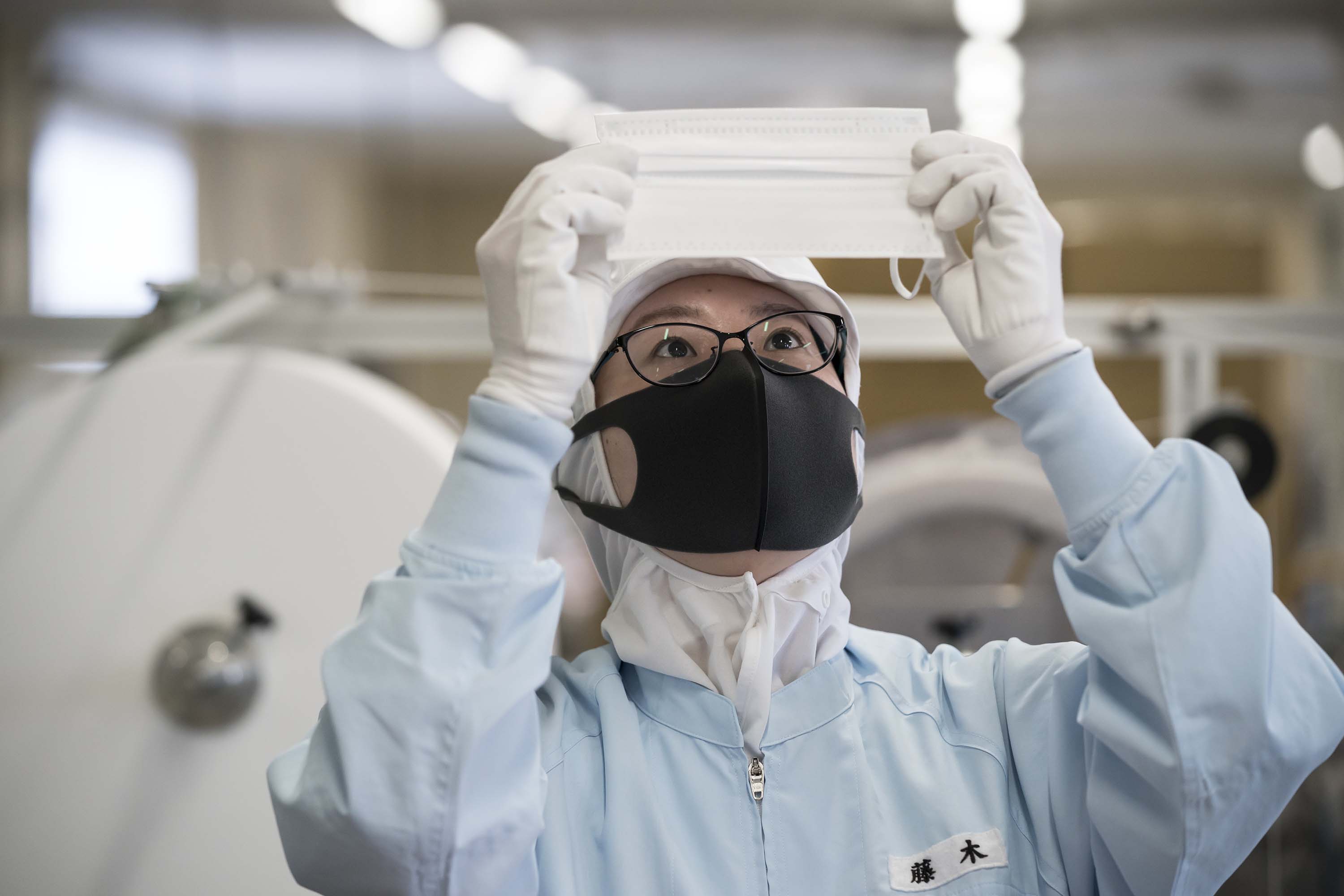 An employee inspects a disposable face mask at a factory in Nagoya, Japan on Thursday.