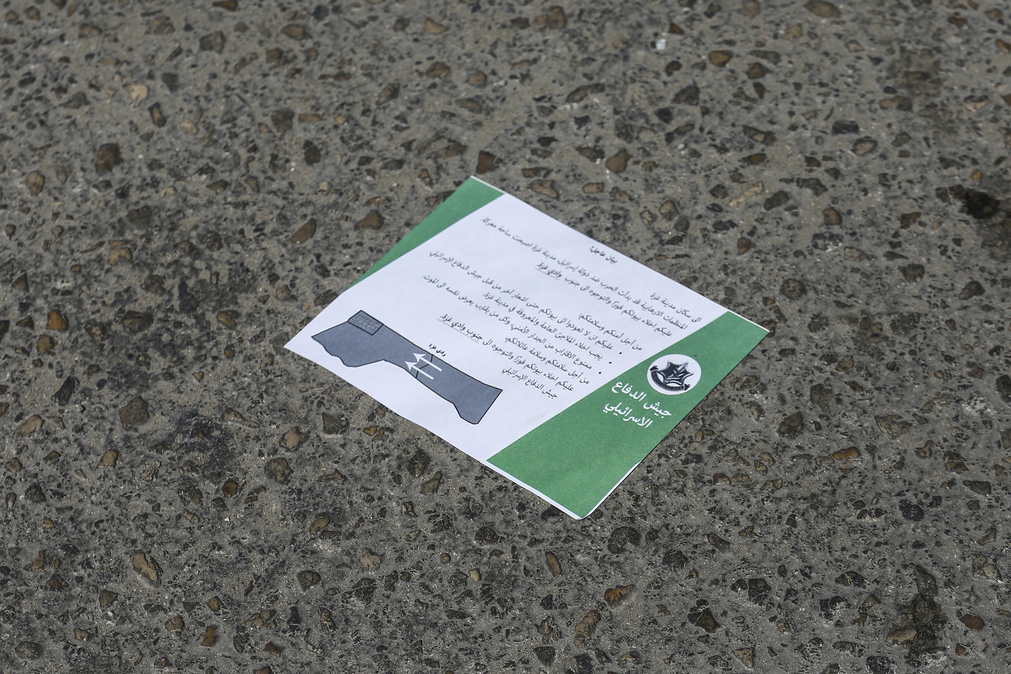 A leaflet lies on the ground dropped by Israeli army planes above Gaza City, asking them to flee to the south of the Strip immediately, on October 13.