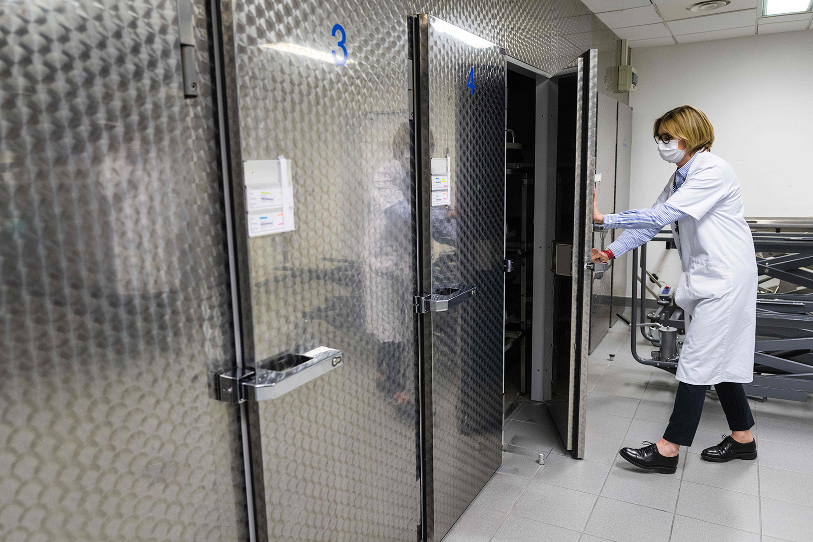 A mortuary service agent closes a refrigeration unit door at the Emile Muller hospital morgue on April 22, 2020, in Mulhouse, eastern France.
