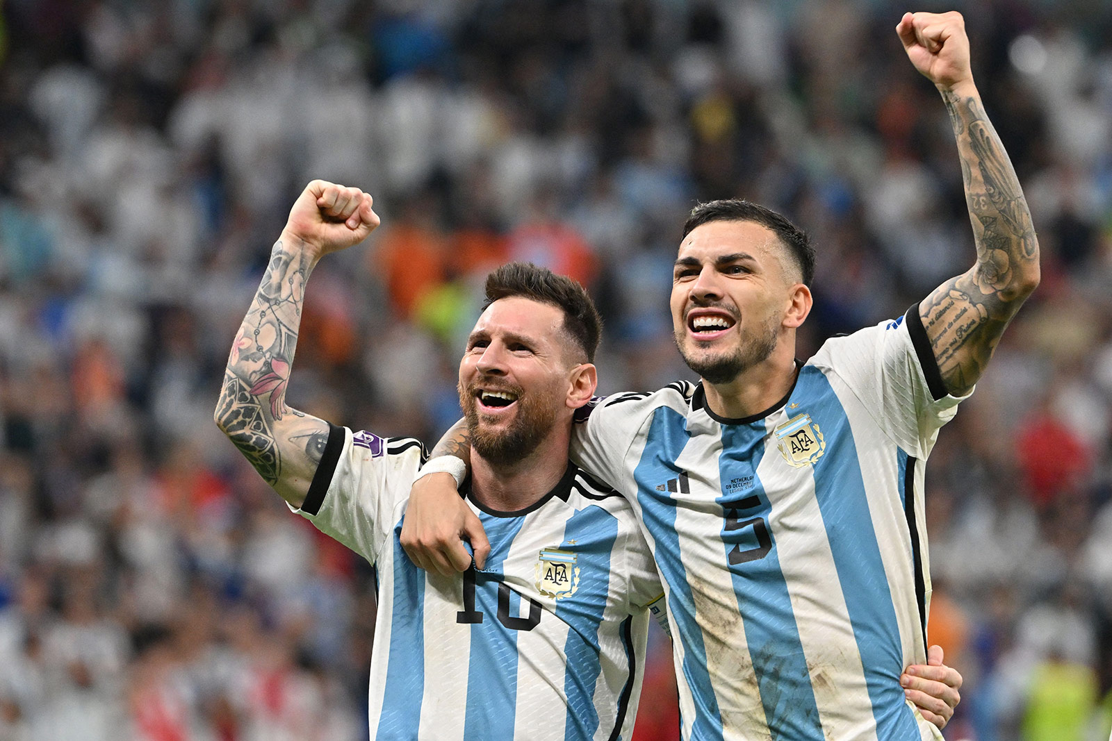 Argentina's Lionel Messi and Leandro Paredes celebrate after defeating Netherlands in a penalty shoot-out on December 9. 
