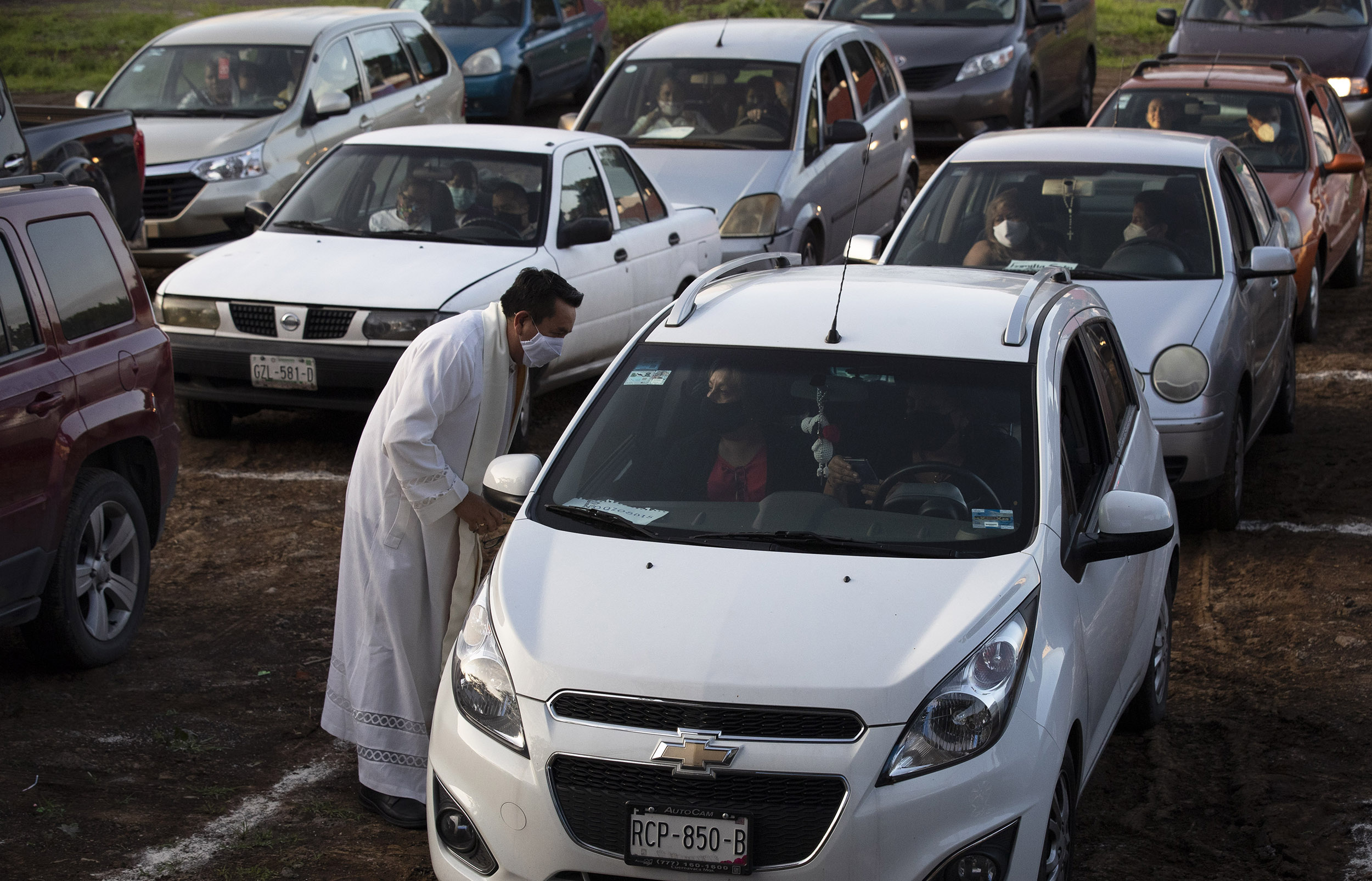 Father Tomas Torres Najera, Vicar of the Cuernavaca Diocese greets parishioners sitting in their cars before Mass at a drive-in cinema in Cuernavaca, Mexico, on Sunday, August 2. 