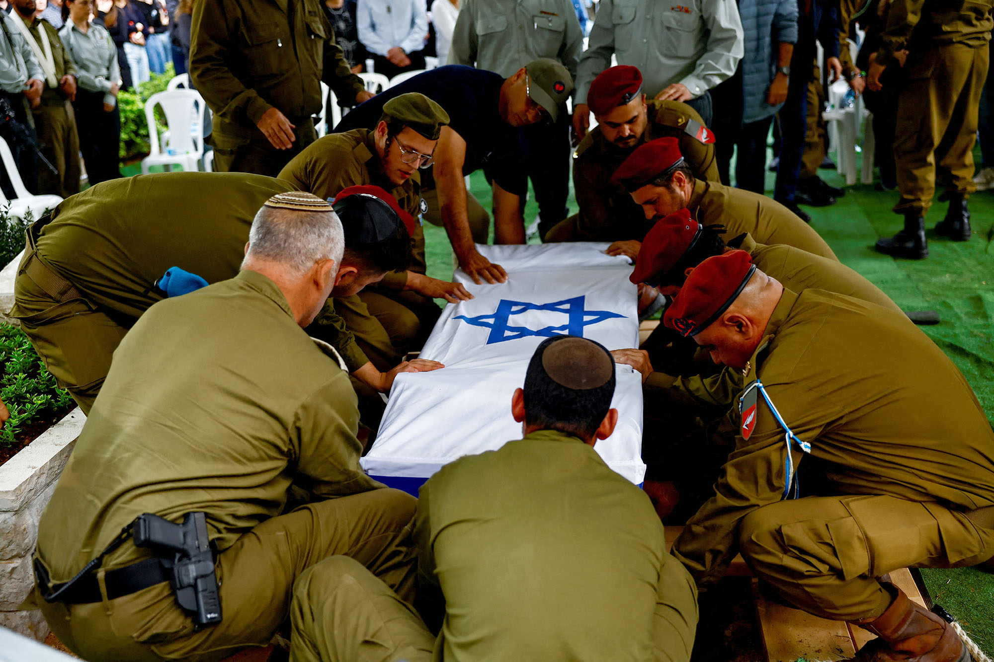 Israeli soldiers lower the casket of reserve soldier Master Sergeant Omri Ben Shachar at his funeral at Kiryat Shaul cemetery in Tel Aviv, Israel, on December 10.