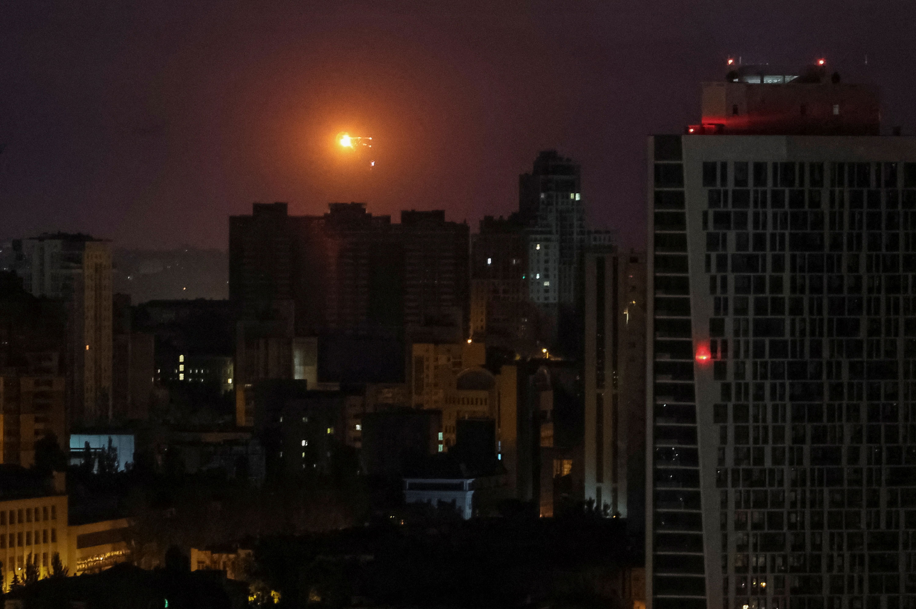 An explosion is seen in the sky over the city during a Russian drone and missile strike in Kyiv, Ukraine, early Monday.