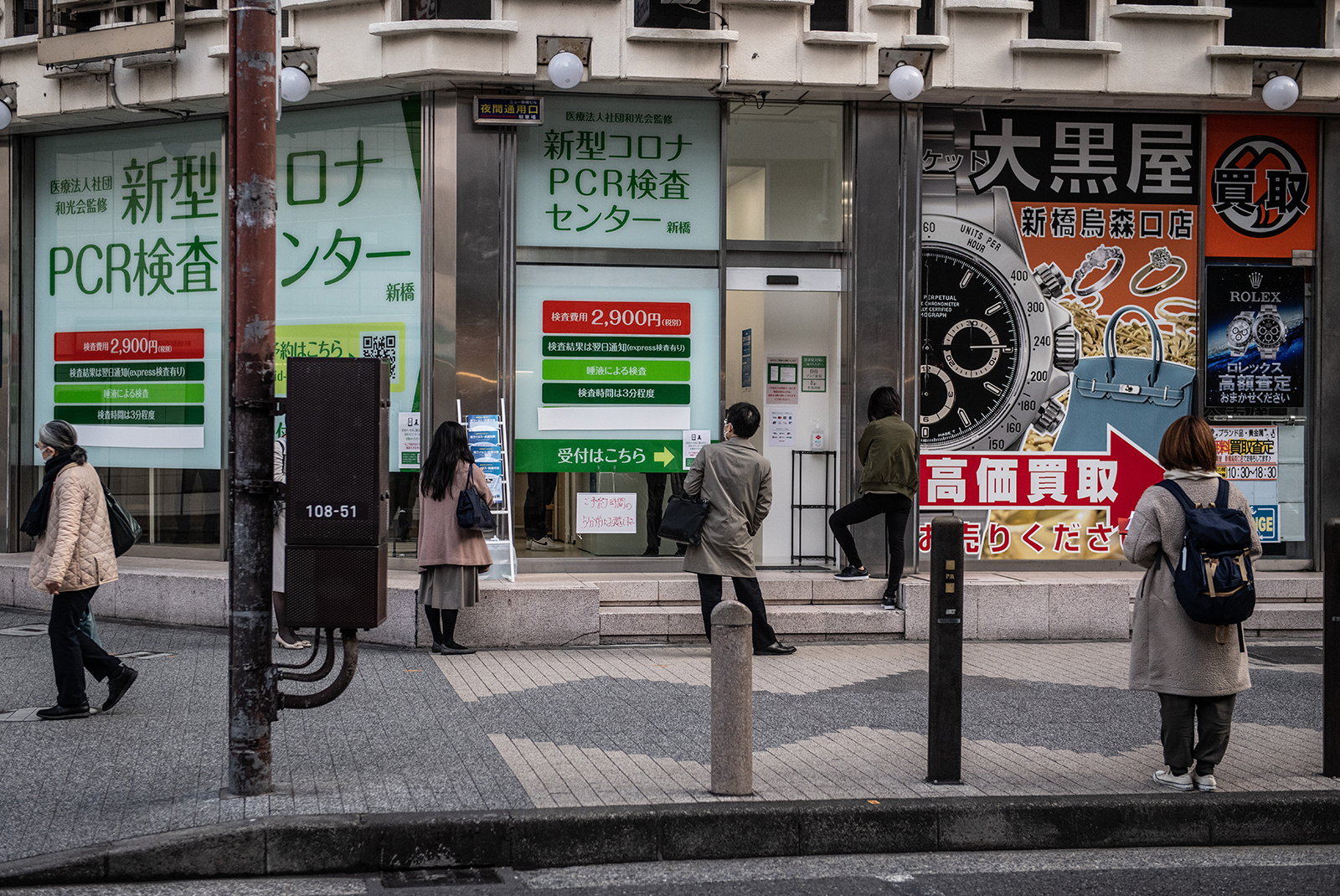 People socially distance as they queue to access a coronavirus PCR testing centre in Tokyo, on December 11.