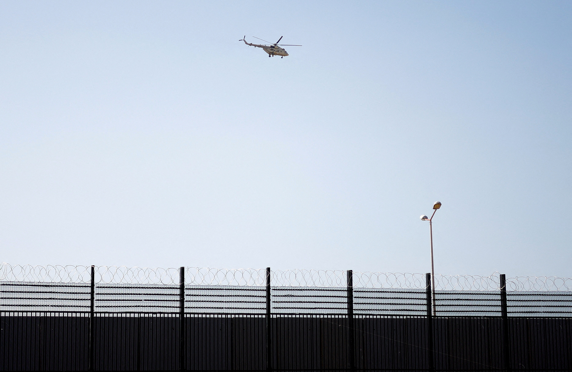 An Egyptian helicopter patrols the fortified border area between Egypt and Gaza as seen from Rafah, Gaza, on February 7.