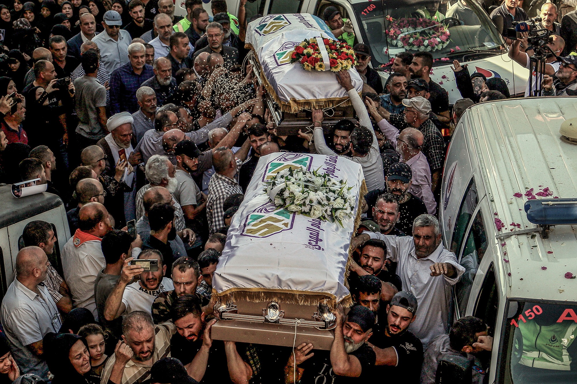 Mourners throw rice over the coffins of three sisters, killed along with their grandmother in an Israeli strike a day earlier, during their funeral procession in the Lebanese southern border village of Blida on November 7.